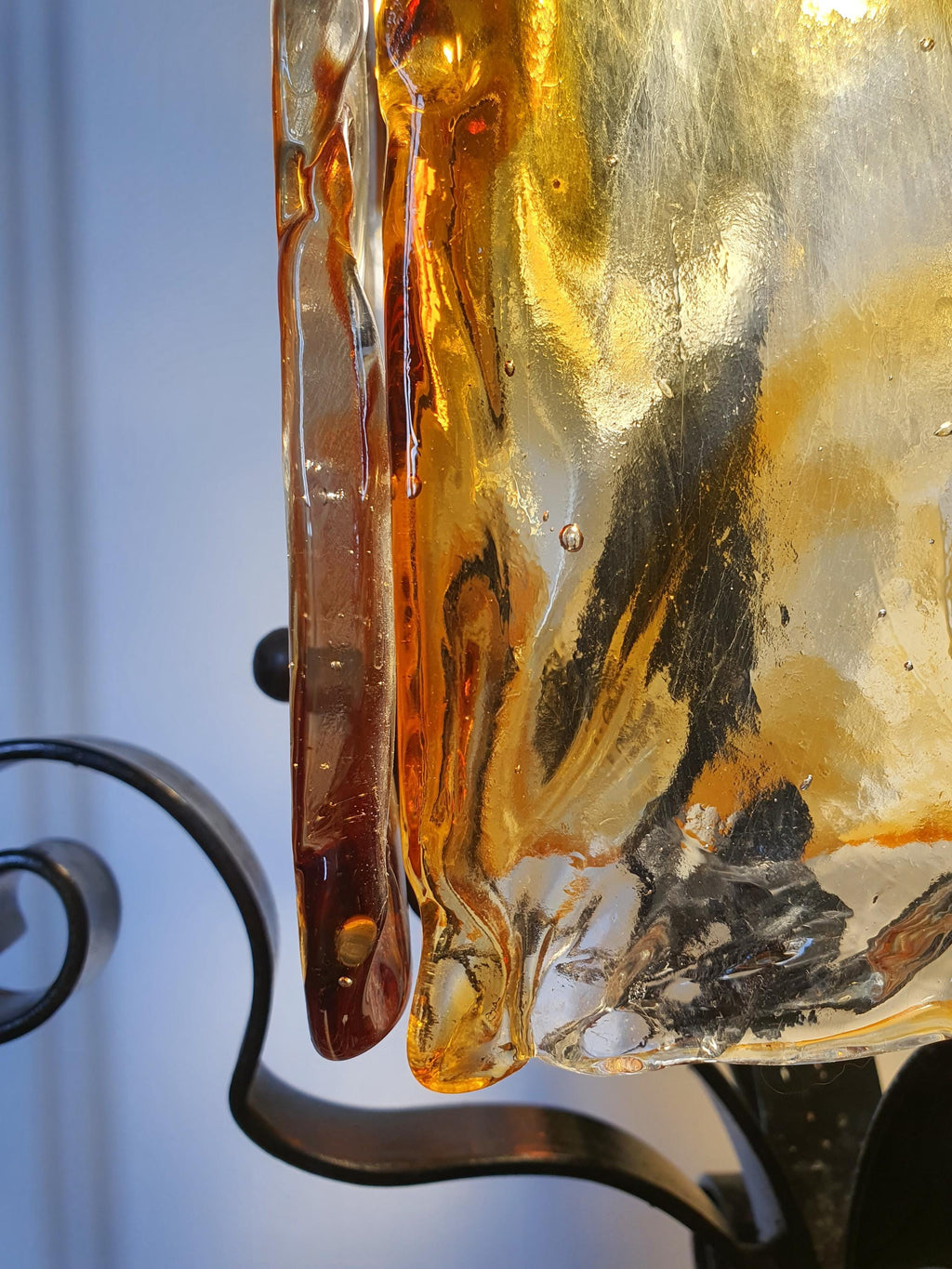 Close-up of amber clear and black Murano art glass diffuser on Mazzega style pendant, rich colour depth and honey tones