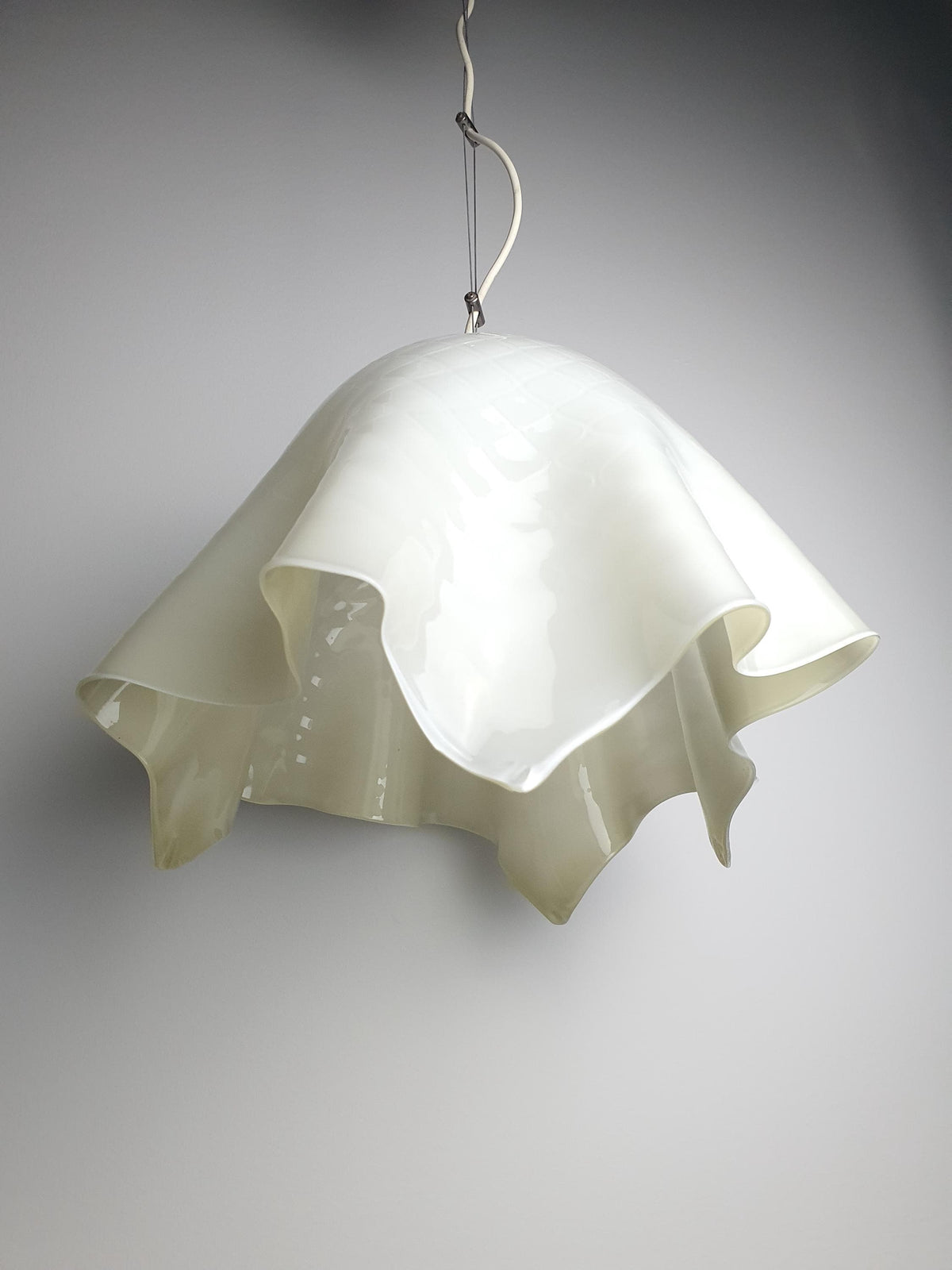 Sculptural green glass shade with flowing organic contours
