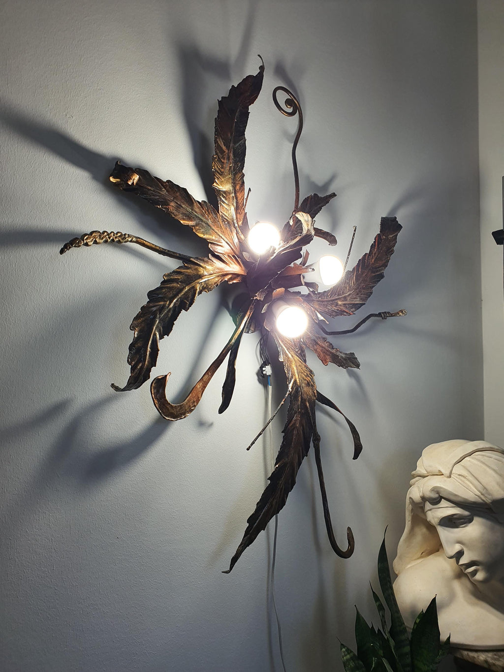 Aged metallic finish on a handcrafted bronze and gold botanical light
