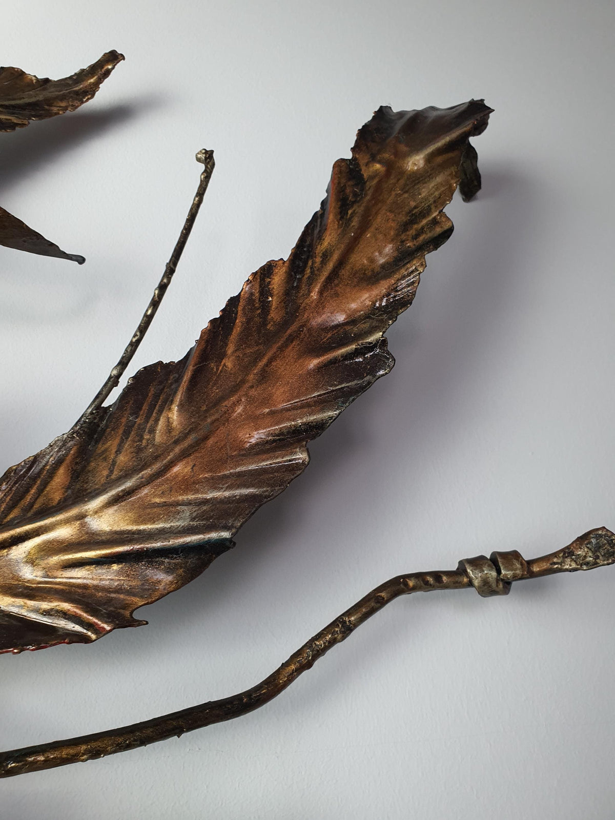 Hand-shaped metal leaves and organic curves on a vintage botanical fixture
