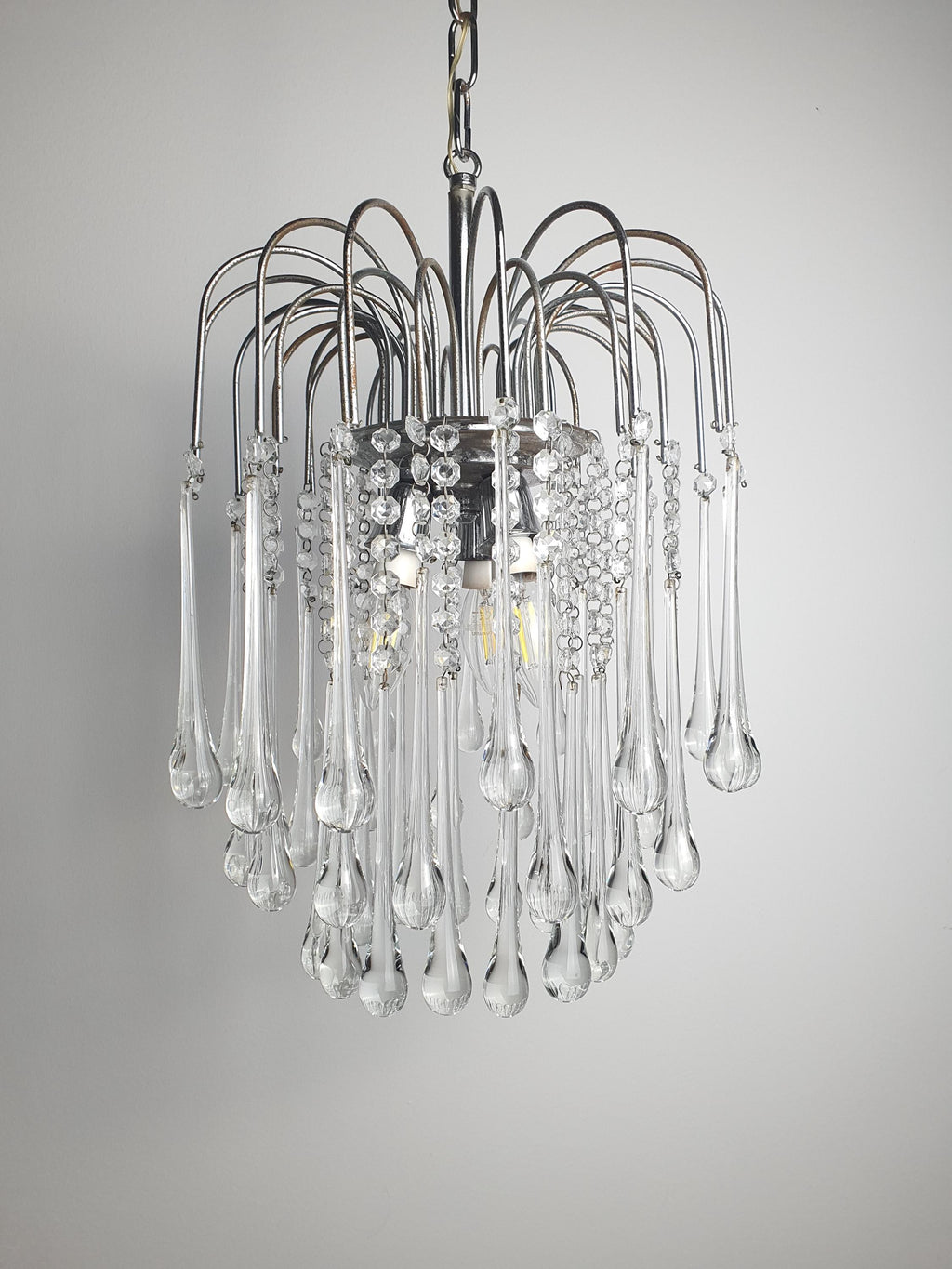 Vintage Murano clear teardrop cascade chandelier in bedroom, sparkling waterfall drops, chrome frame, Hollywood Regency