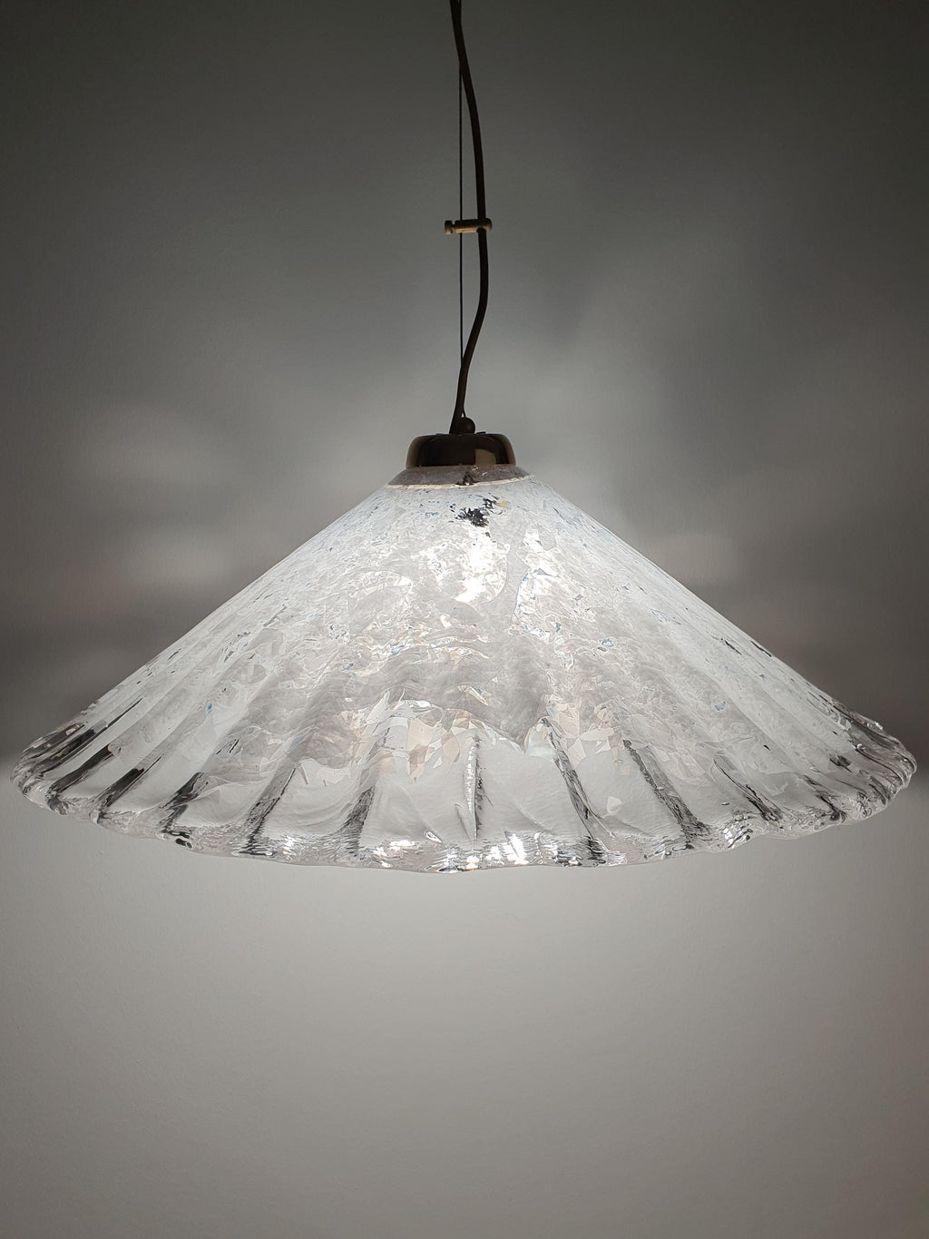 Vintage Murano shell pendant installed above dining table, organic coastal form, warm ambient glow