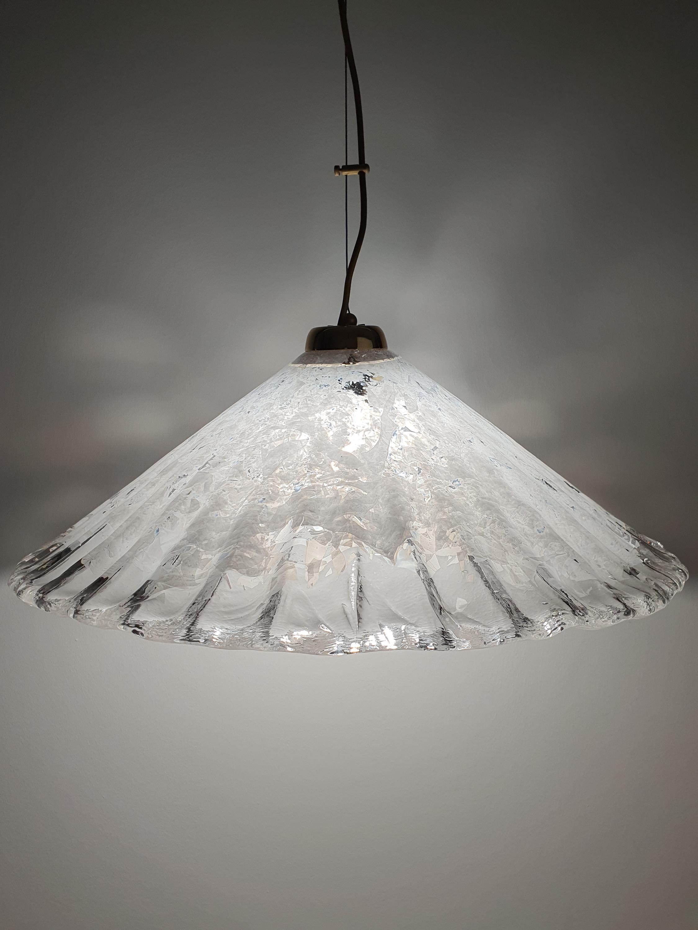 Vintage Murano shell pendant installed above dining table, organic coastal form, warm ambient glow