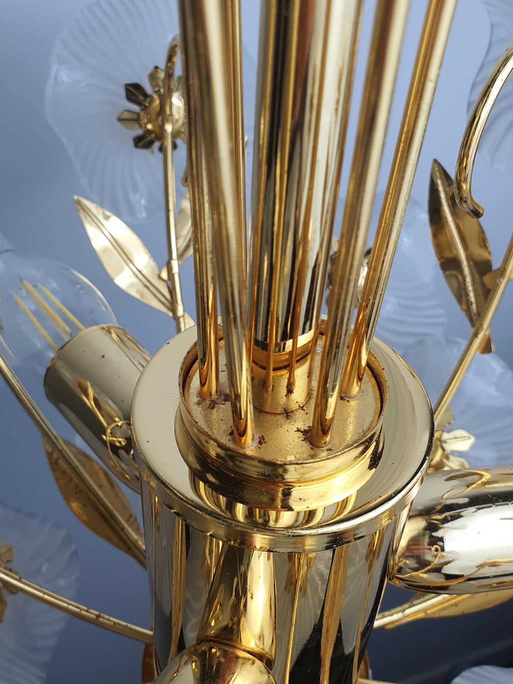 Gold-toned metal frame detail on vintage Murano white flower bouquet chandelier, warm gold structure and white glass blooms