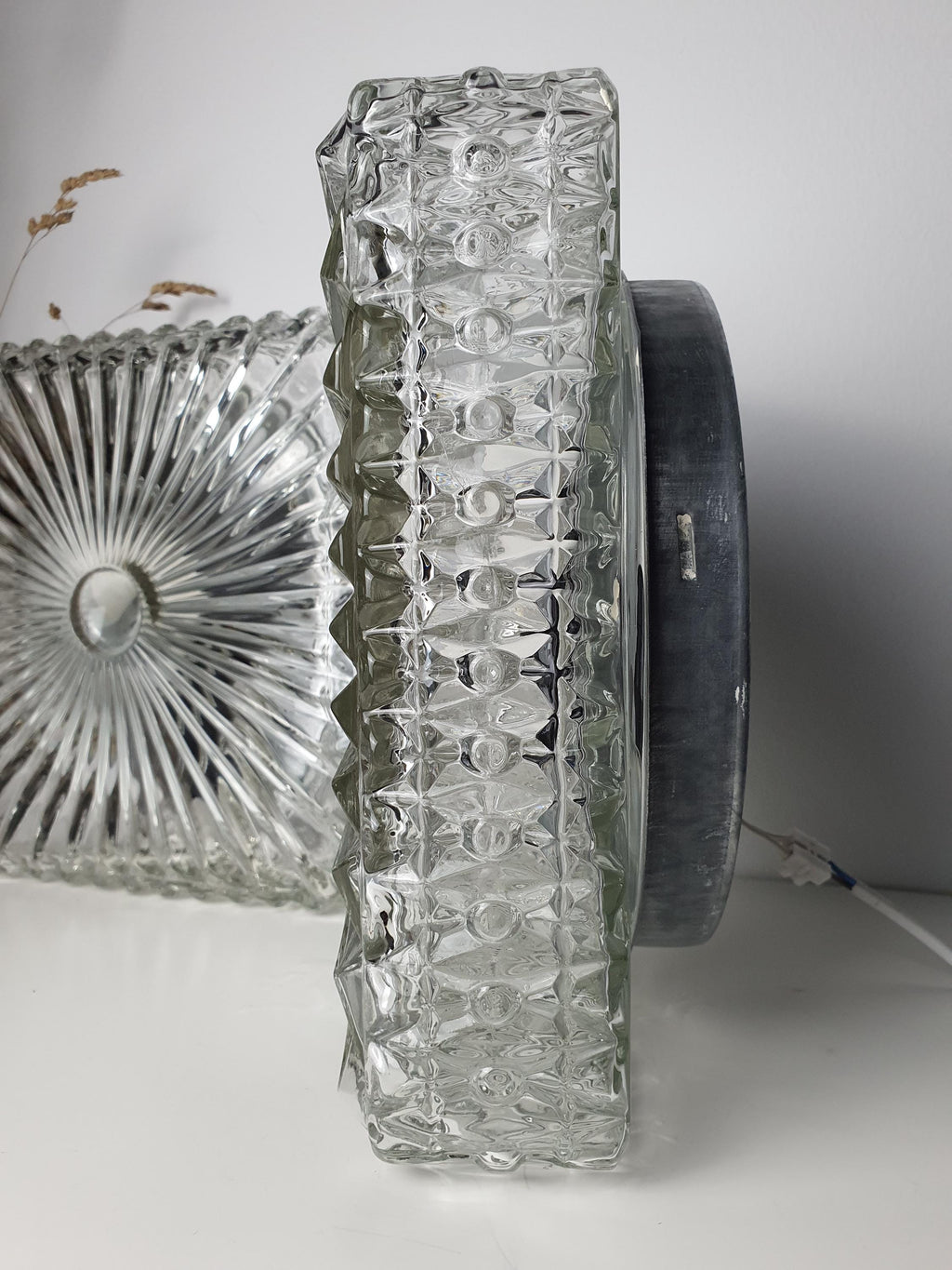 Detail of the stamped texture on a clear glass wall sconce
