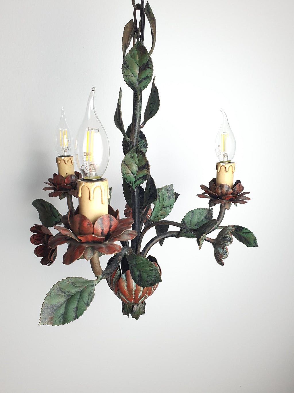 Poppy-inspired red flower and green leaf details on a vintage tole light
