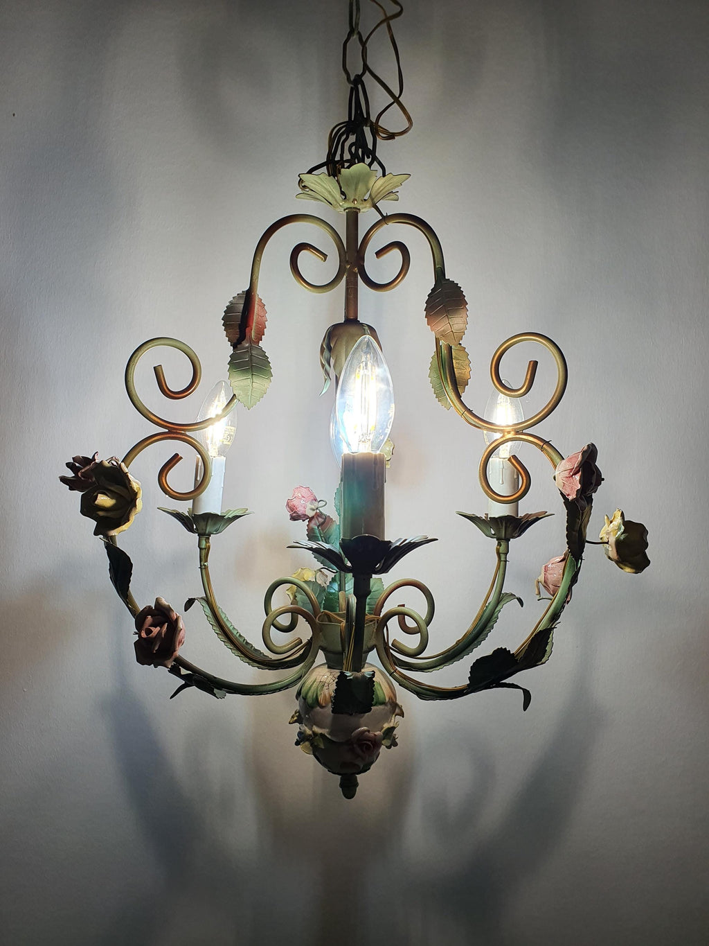 Detail of paint patina and color loss on green toleware arm, vintage 1950s Italian chandelier