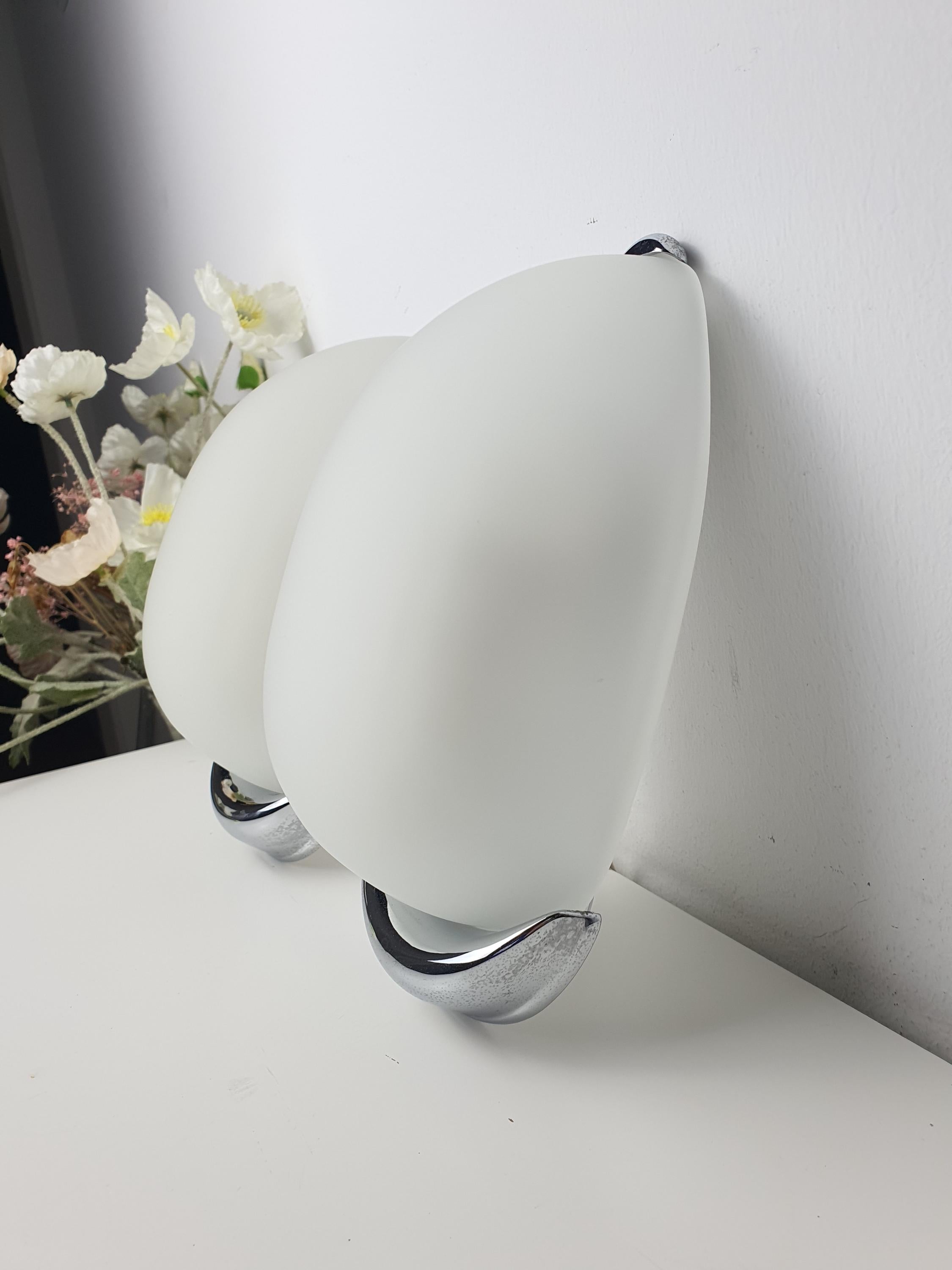 Italian egg-form wall sconce front view, satin frosted glass capsule shade on chrome base, minimalist design