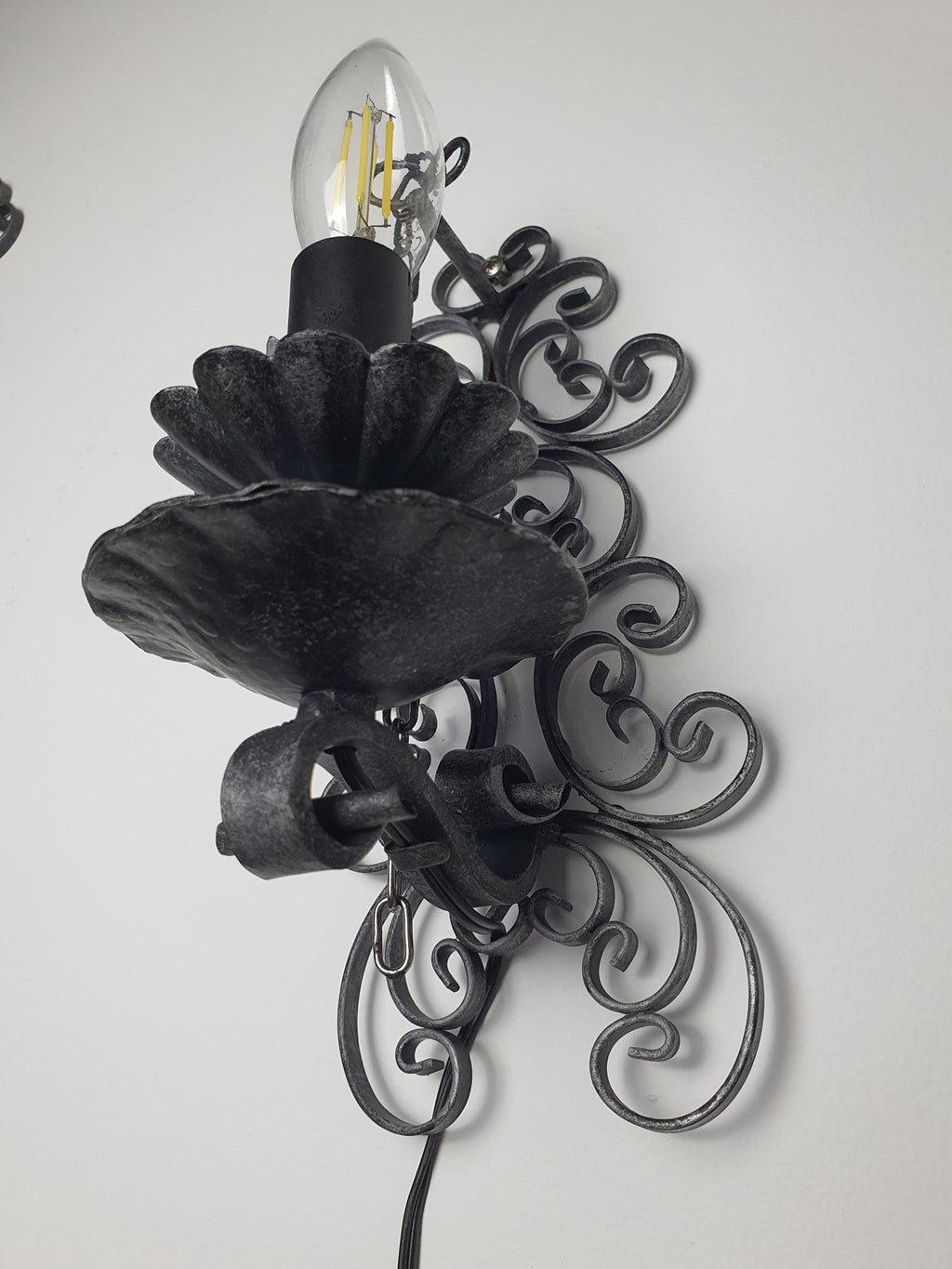 Castle-inspired wrought iron wall light — bold architectural silhouette, side profile