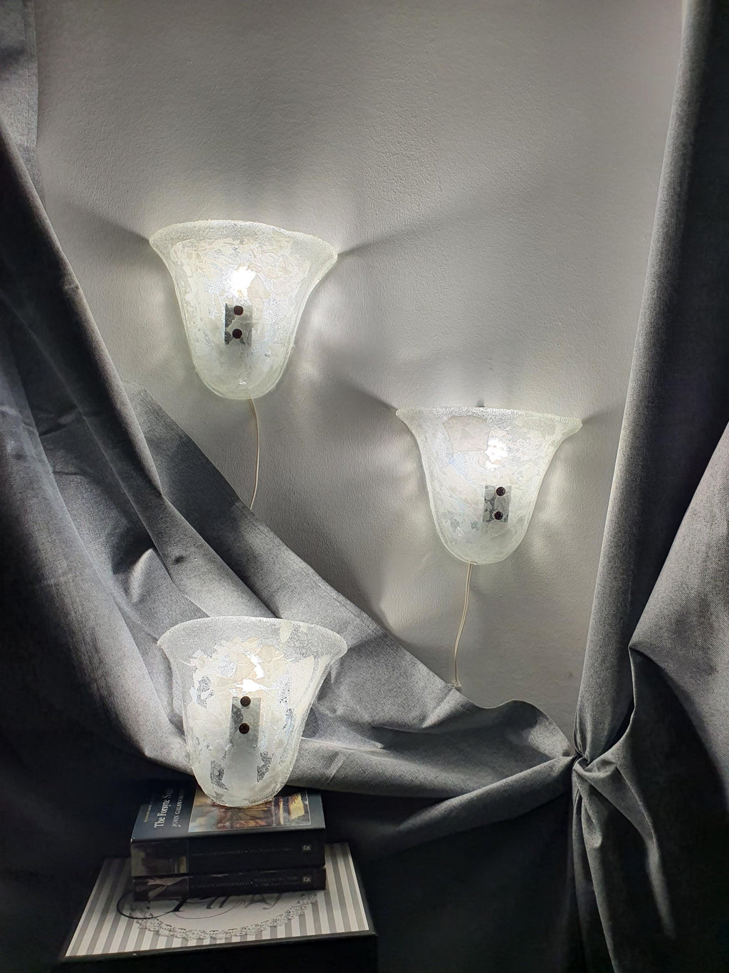 Set of 3 Murano glass shell sconces lit, soft diffused glow through clear and white inclusion glass, hallway installation