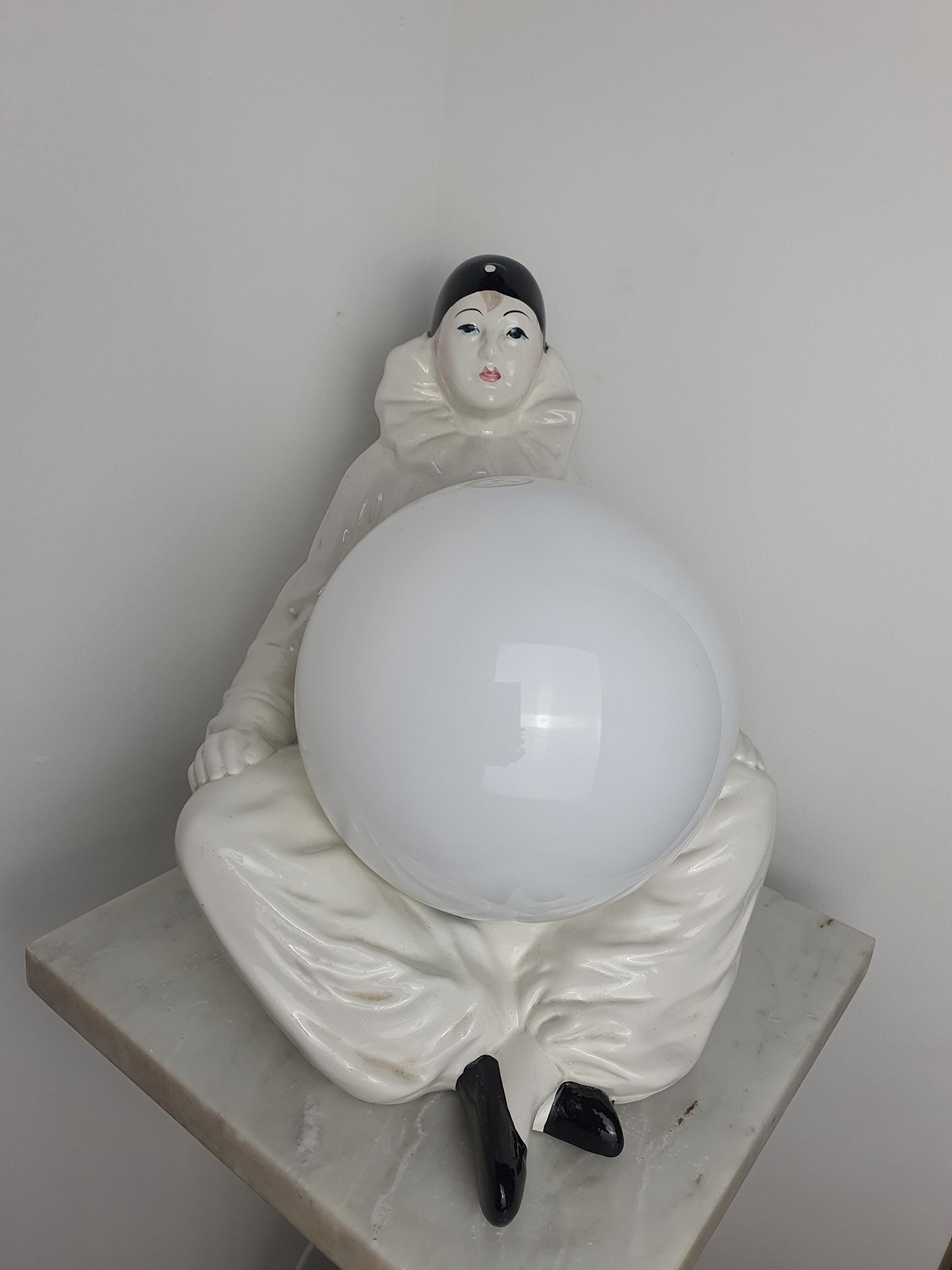 Vintage Italian Pierrot clown ceramic lamp in bedroom, warm white globe glow, theatrical commedia dell'arte accent light