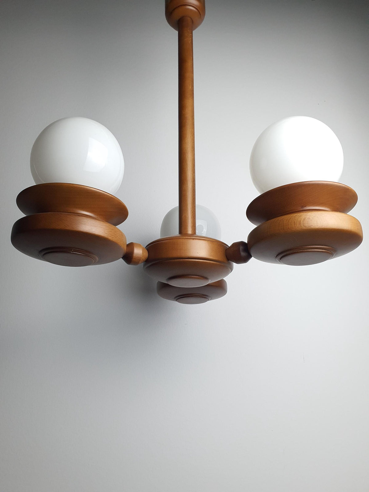 Close-up of milk glass globe shade on vintage Space Age Sputnik chandelier, soft even ambient diffusion, beautifully preserved