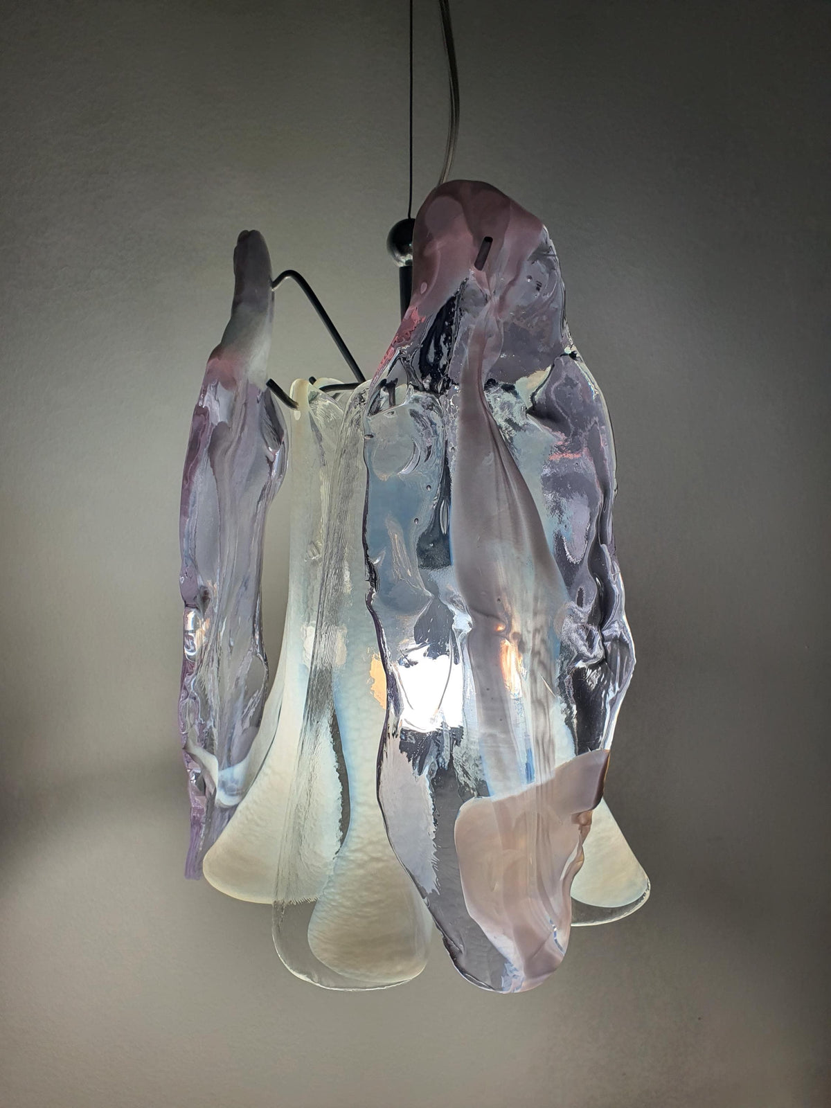 Organic floral silhouette of a compact clear and lilac chandelier
