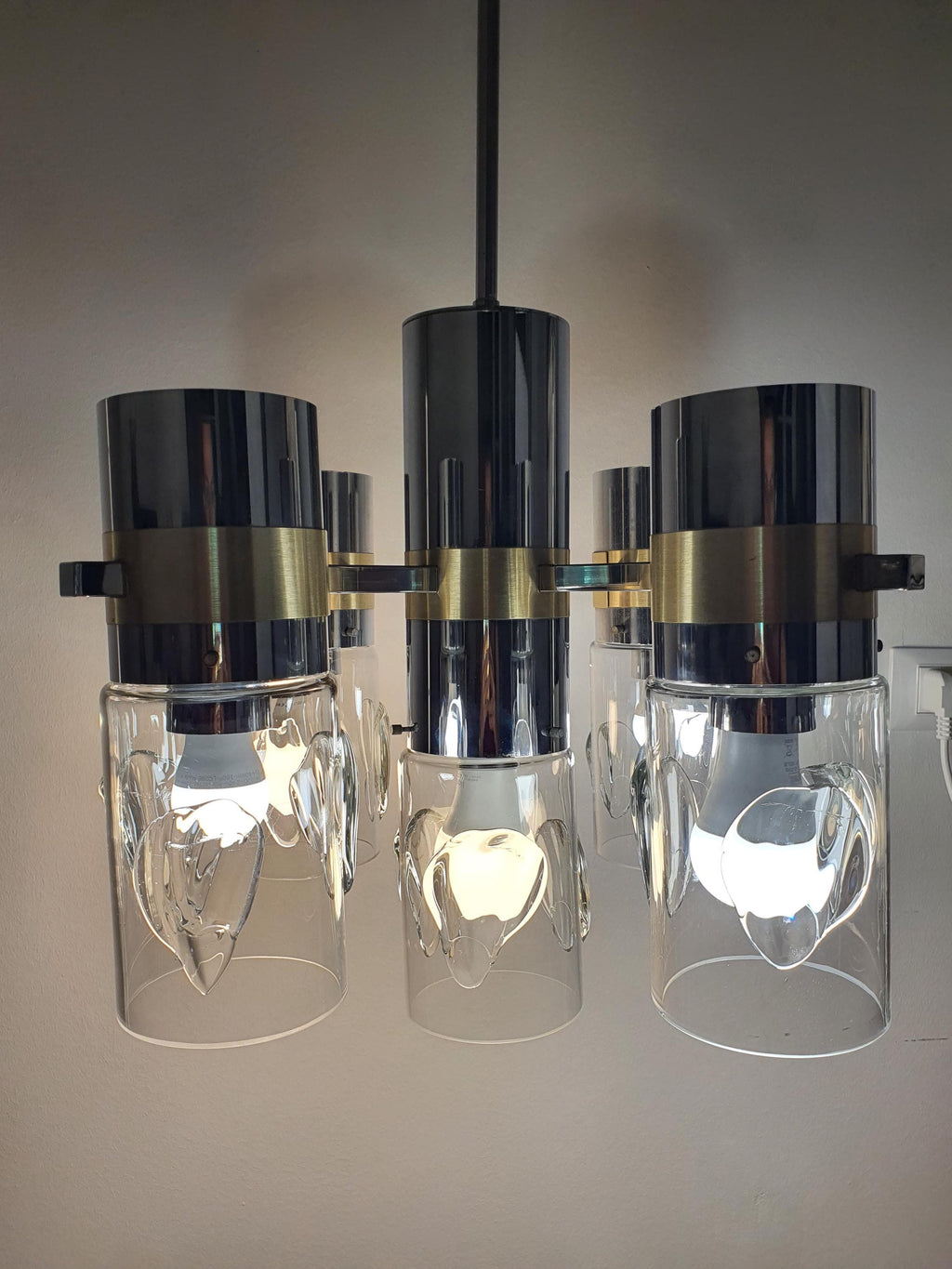 Vintage Space Age Sputnik chandelier lit, warm chrome gold five-arm glow, handcrafted glass diffusers, dramatic MCM interior