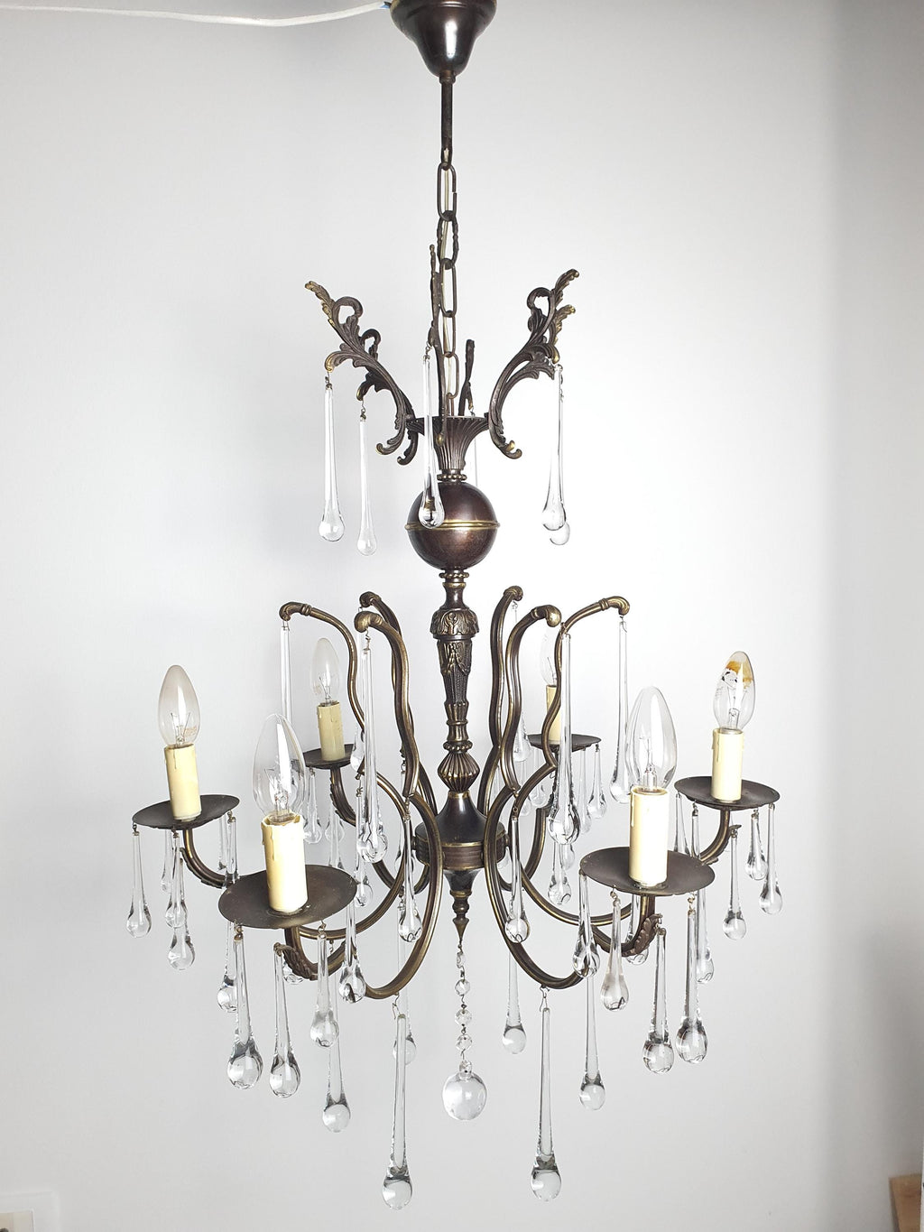 Vintage Italian brass Murano teardrop chandelier lit, dazzling clear glass reflections, warm glow, grand dining room setting