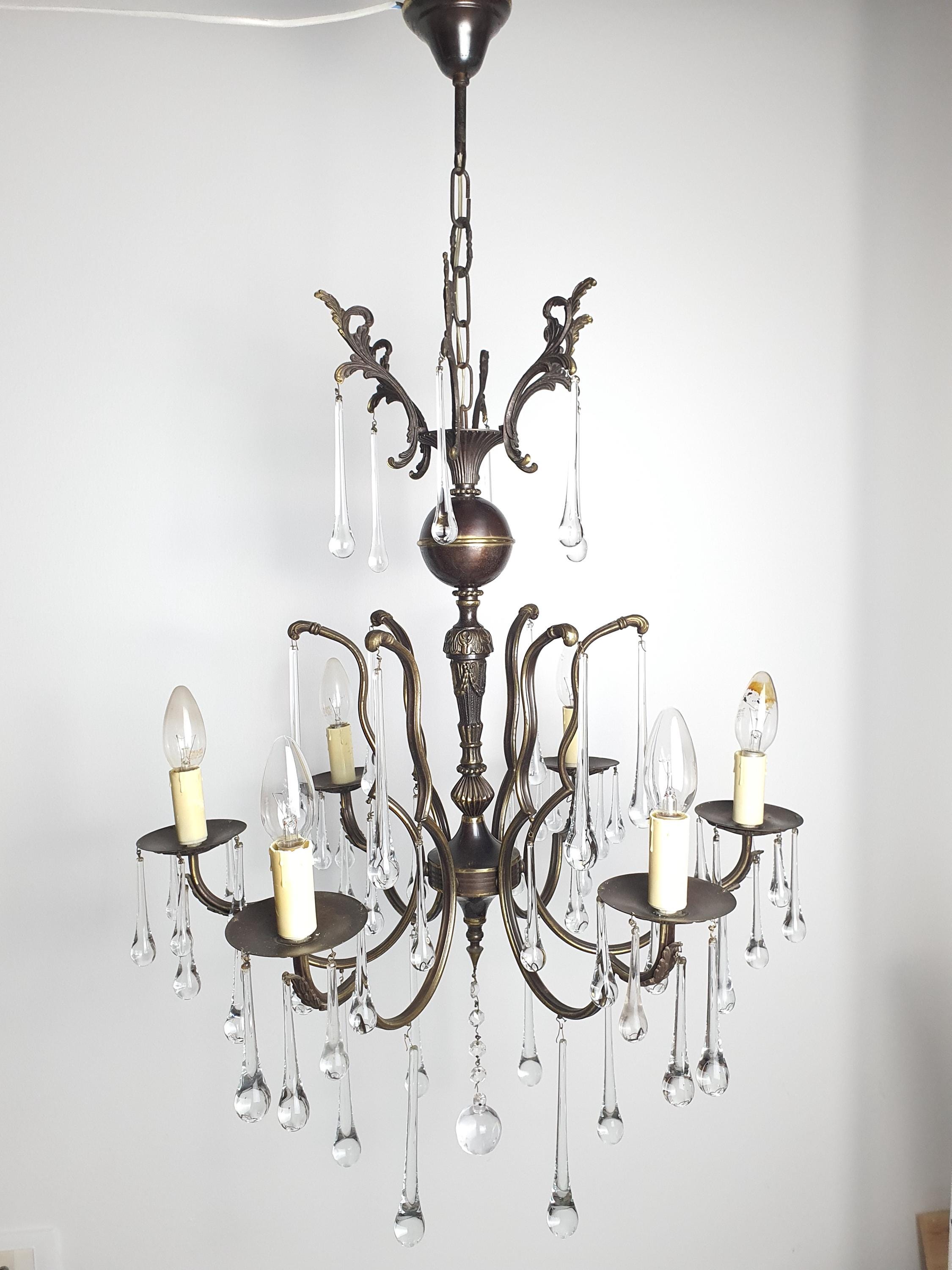 Vintage Italian brass Murano teardrop chandelier lit, dazzling clear glass reflections, warm glow, grand dining room setting