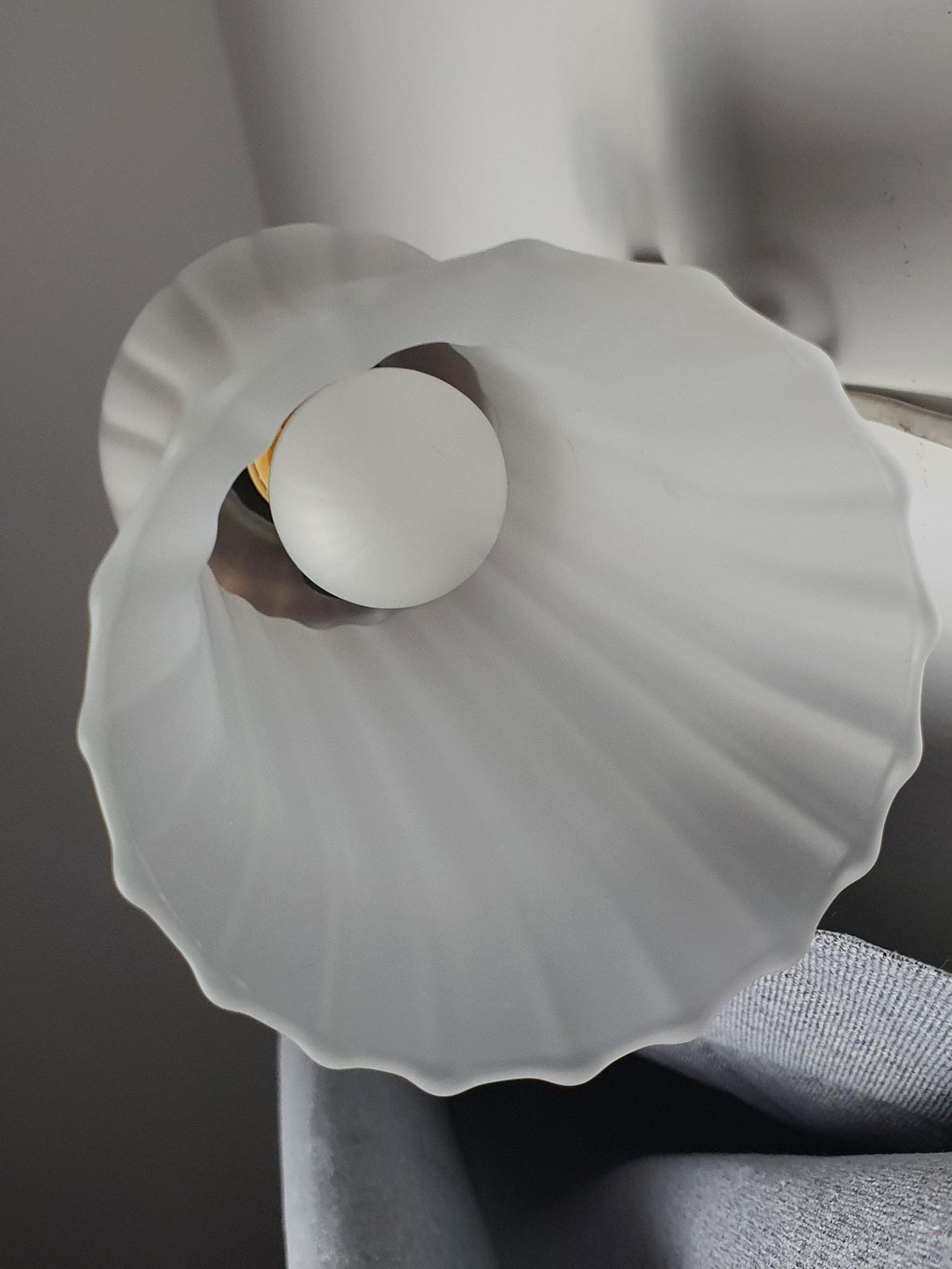 Close-up of satin frosted flute glass shade on vintage Italian wall sconce, elongated form, soft diffused finish