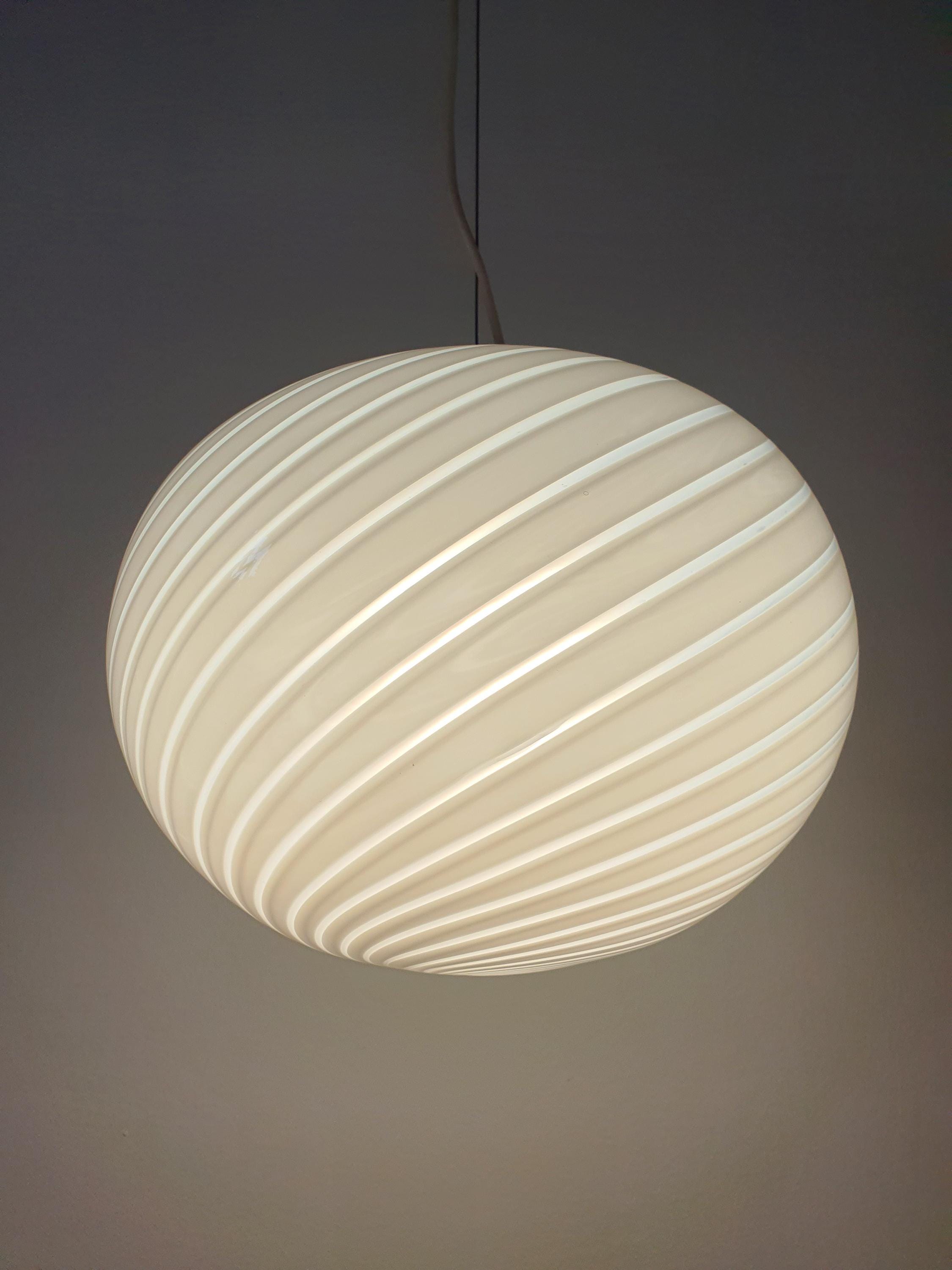 Vintage Murano white swirl globe pendant in bedroom, soft white swirl glow, understated elegant Italian lighting