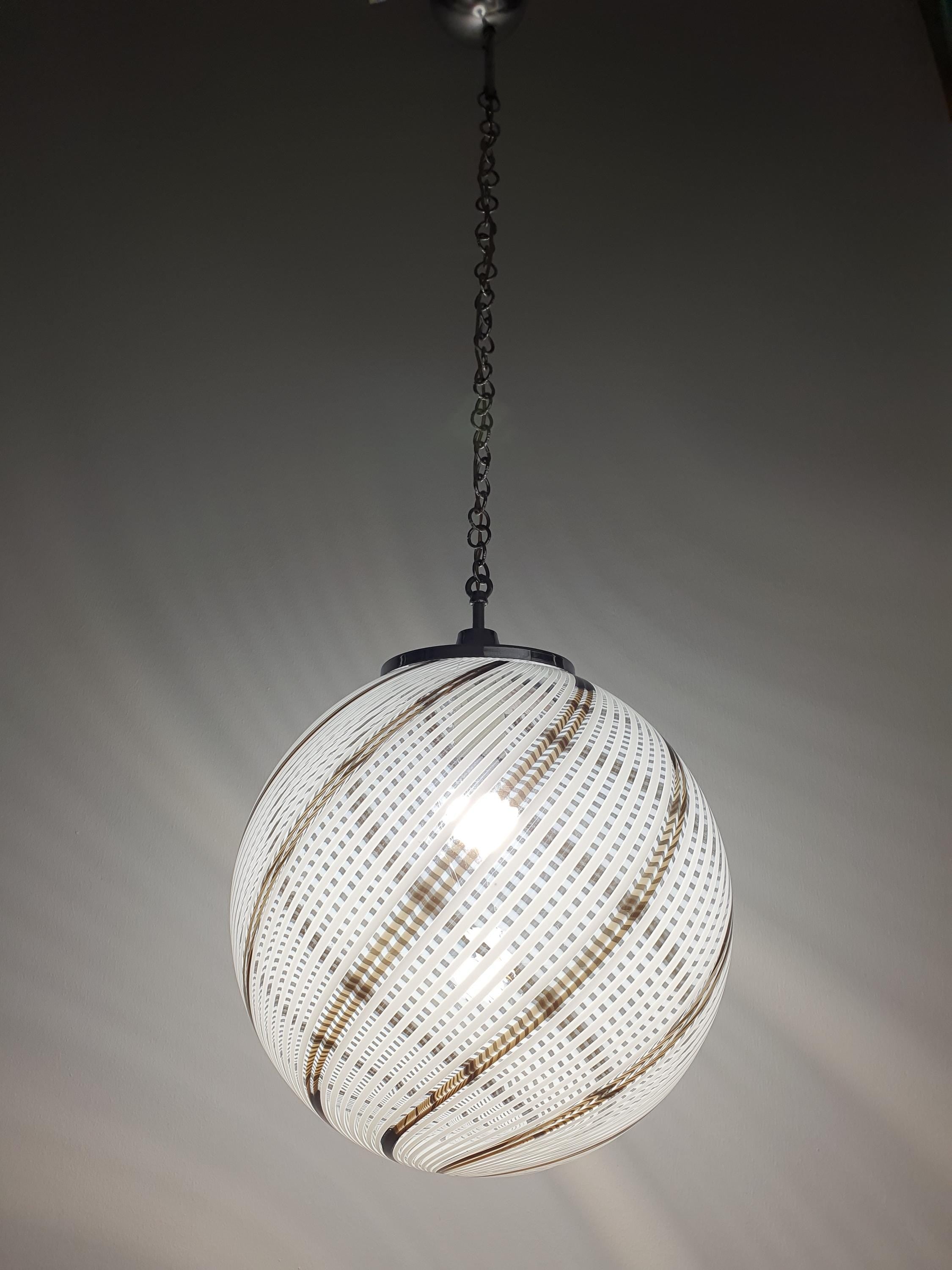 Venini-style Murano glass globe pendant front view, white and brown filigree lines in clear glass