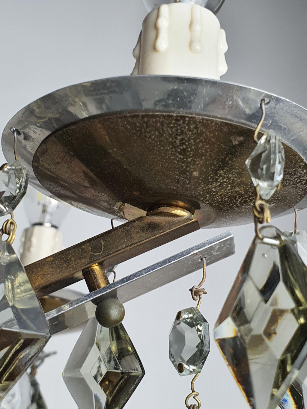 Close-up of smoky grey crystal drops on vintage Art Deco 6-arm brass and chrome chandelier, geometric arrangement