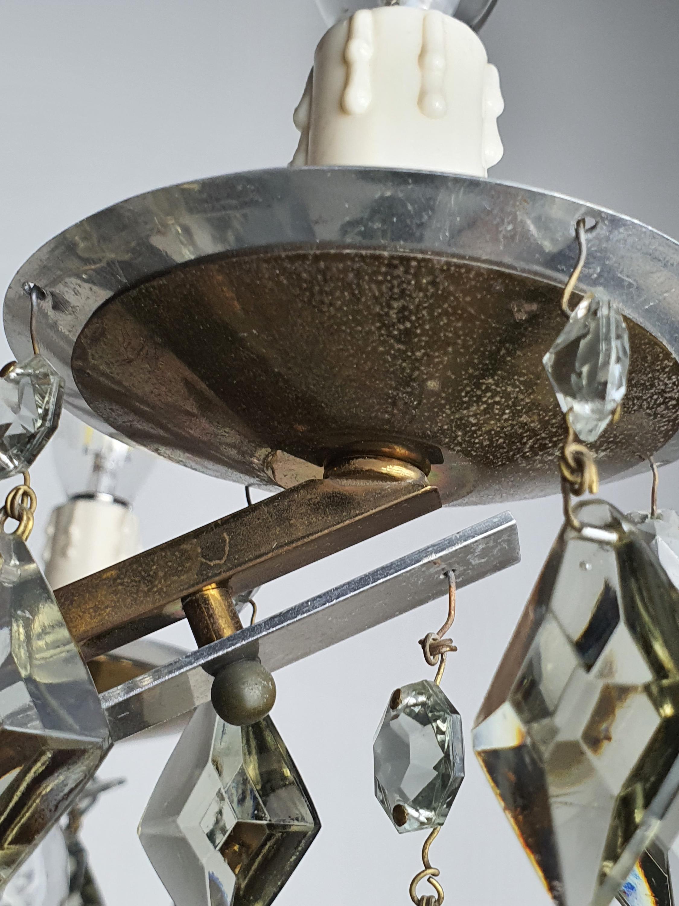 Close-up of smoky grey crystal drops on vintage Art Deco 6-arm brass and chrome chandelier, geometric arrangement