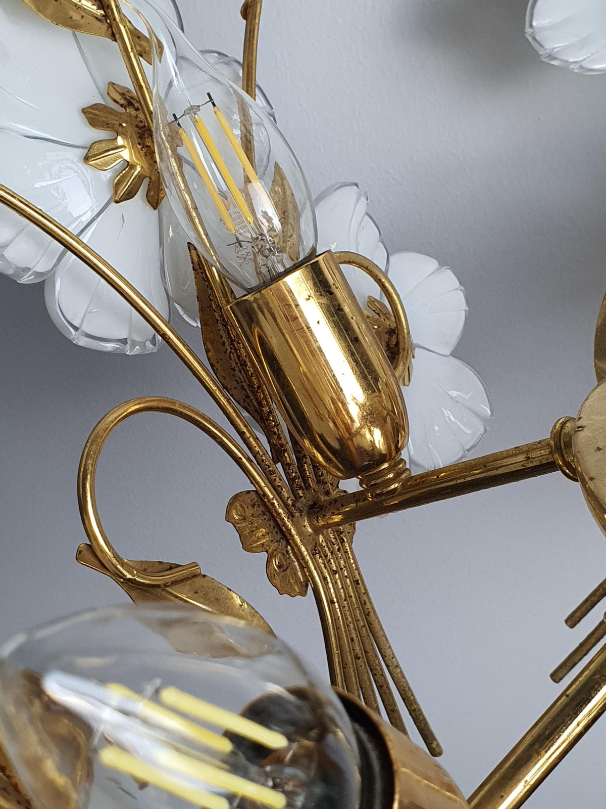 Close-up of gold-tone bowl and flower retainers on vintage 1980s Murano chandelier, varied historic restoration details