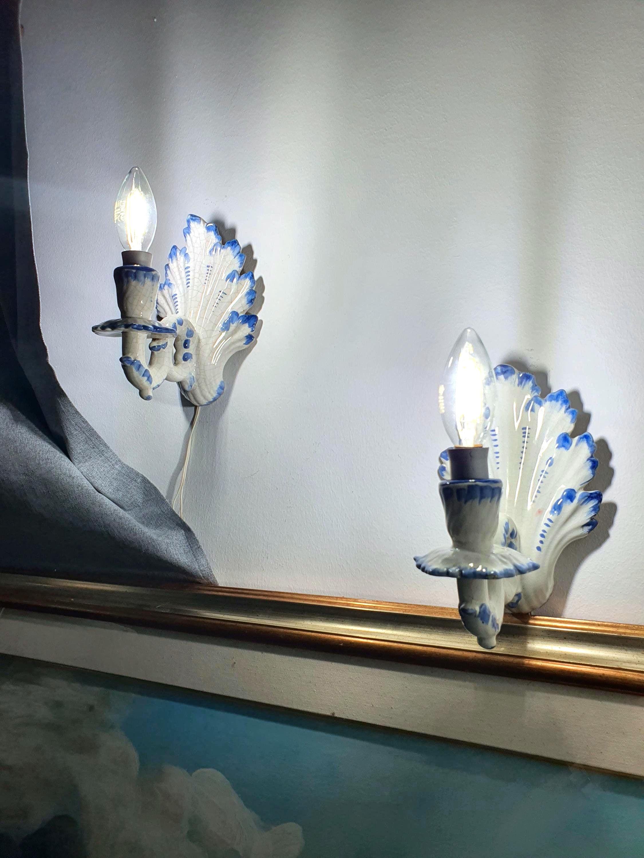 Pair of vintage Italian Bassano ceramic wall sconces, white glaze with hand-painted blue decorative details, age crazing, 1970s–1980s