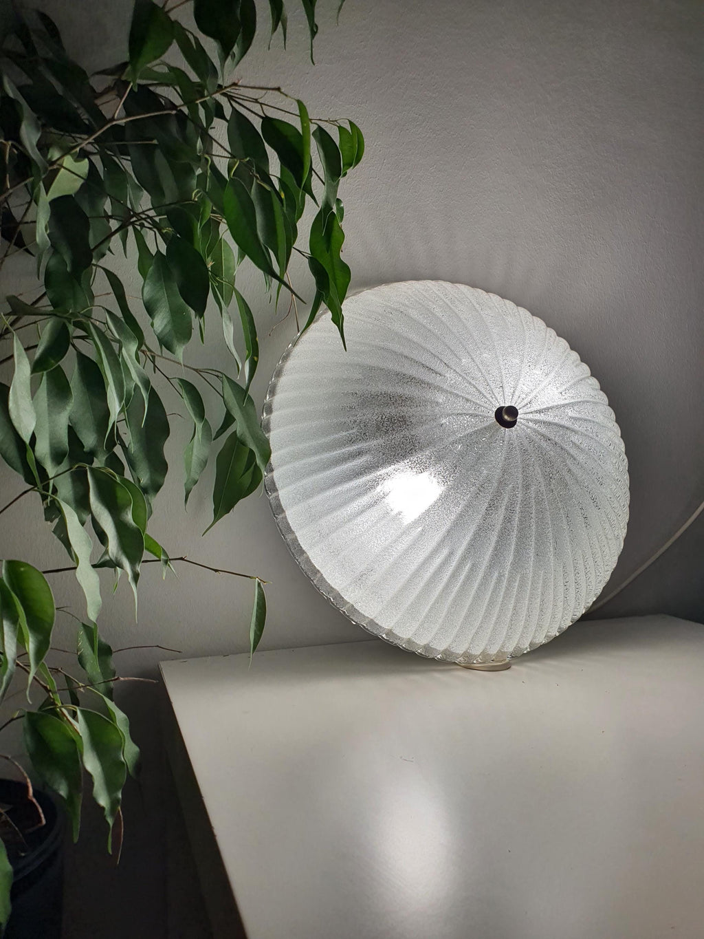 Vintage Murano ribbed shell flush mount lit, crystalline ribbed glass reflections, soft iced glow, Art Deco MCM interior

