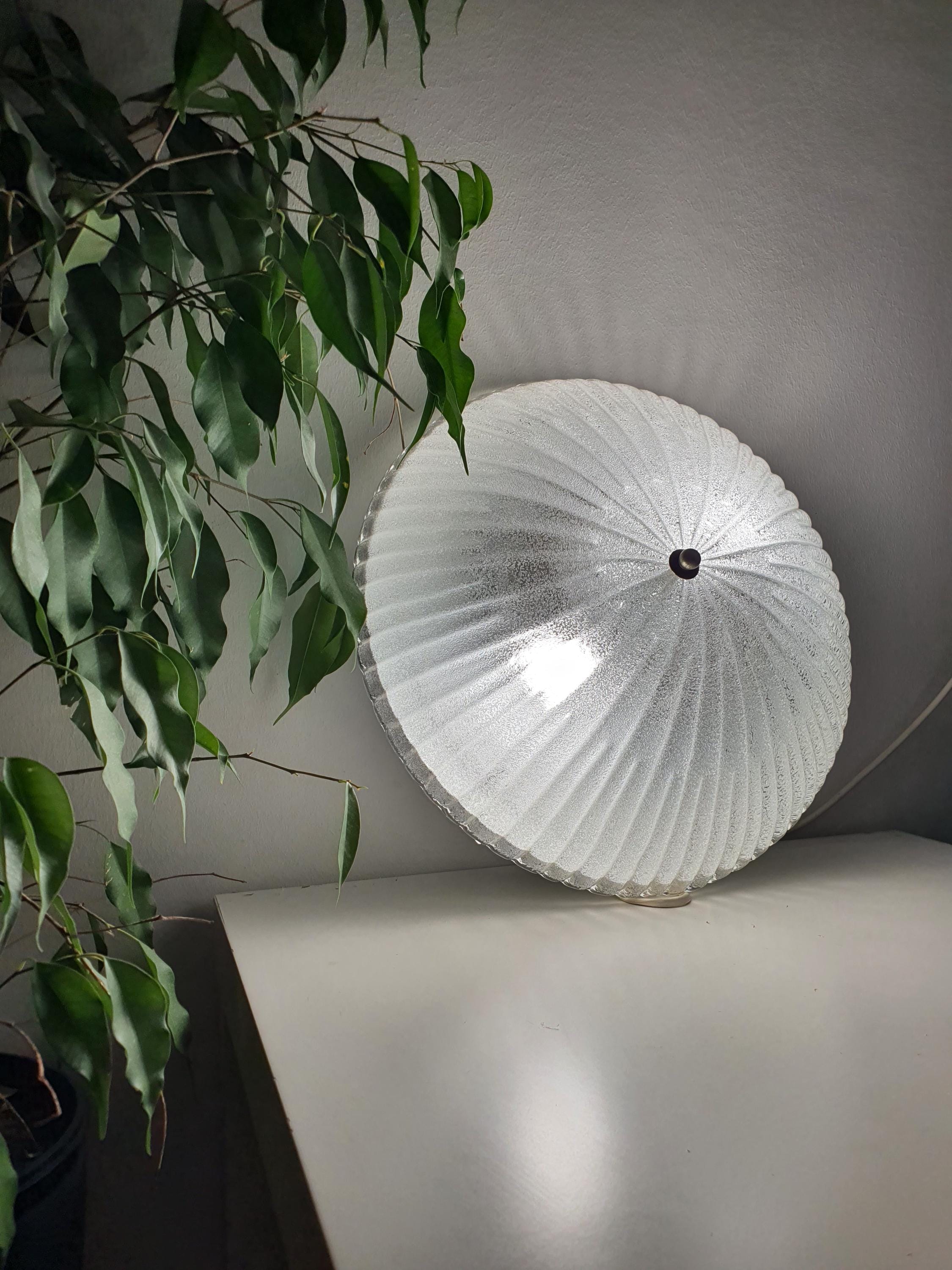 Vintage Murano ribbed shell flush mount lit, crystalline ribbed glass reflections, soft iced glow, Art Deco MCM interior

