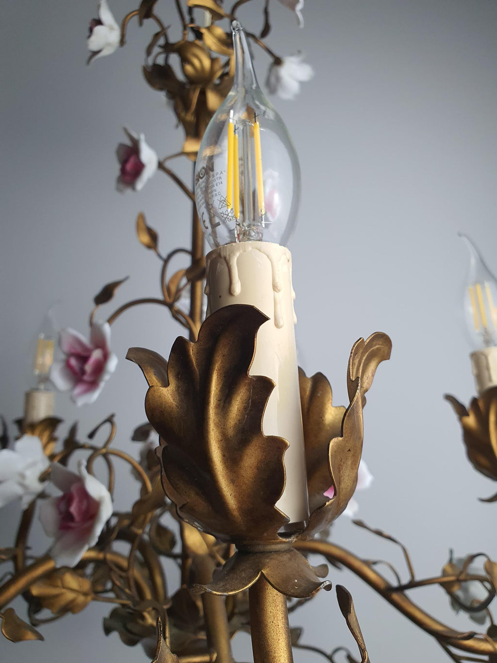 Small losses and chipped petals on the chandelier’s porcelain roses
