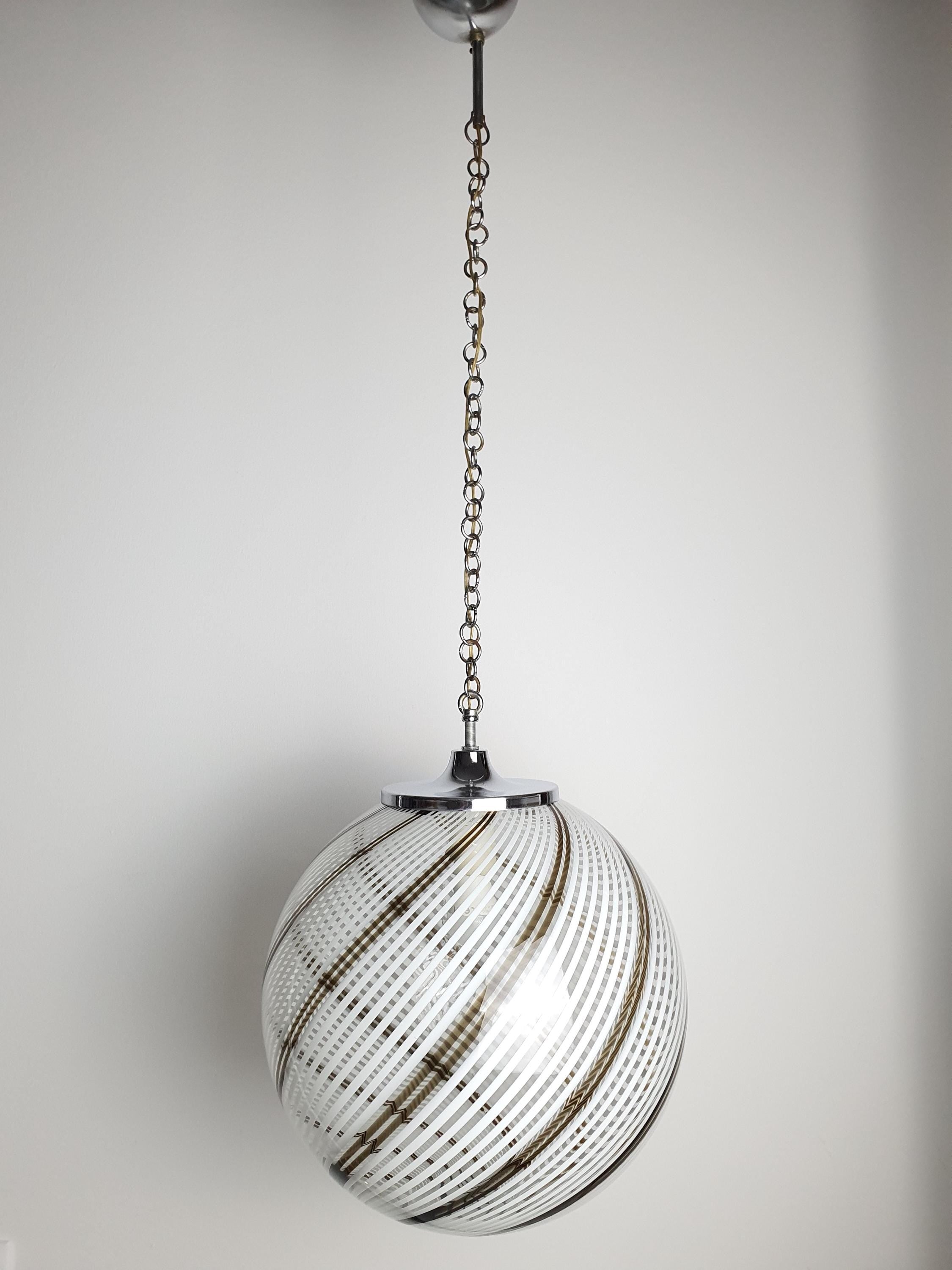 Vintage Murano filigrana globe pendant installed above dining table, Mid-Century Modern interior