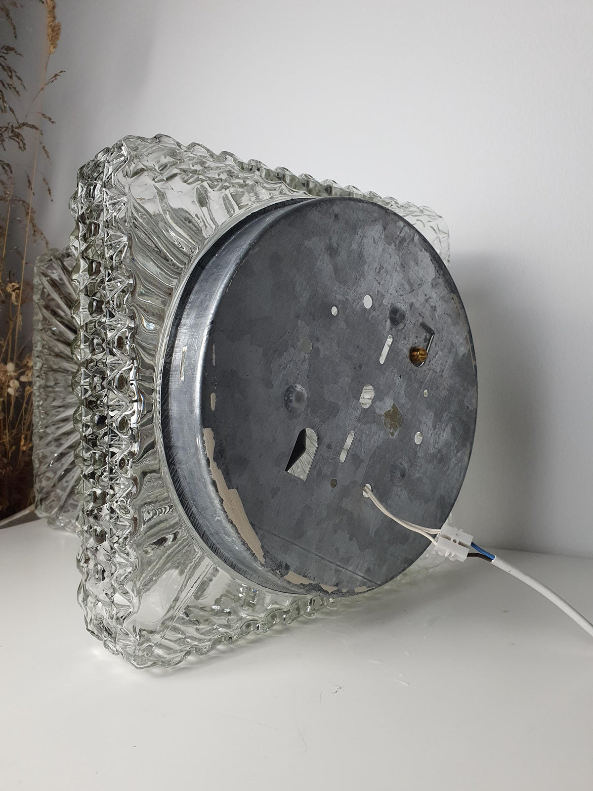 Chips at the base of a vintage glass shade before mounting
