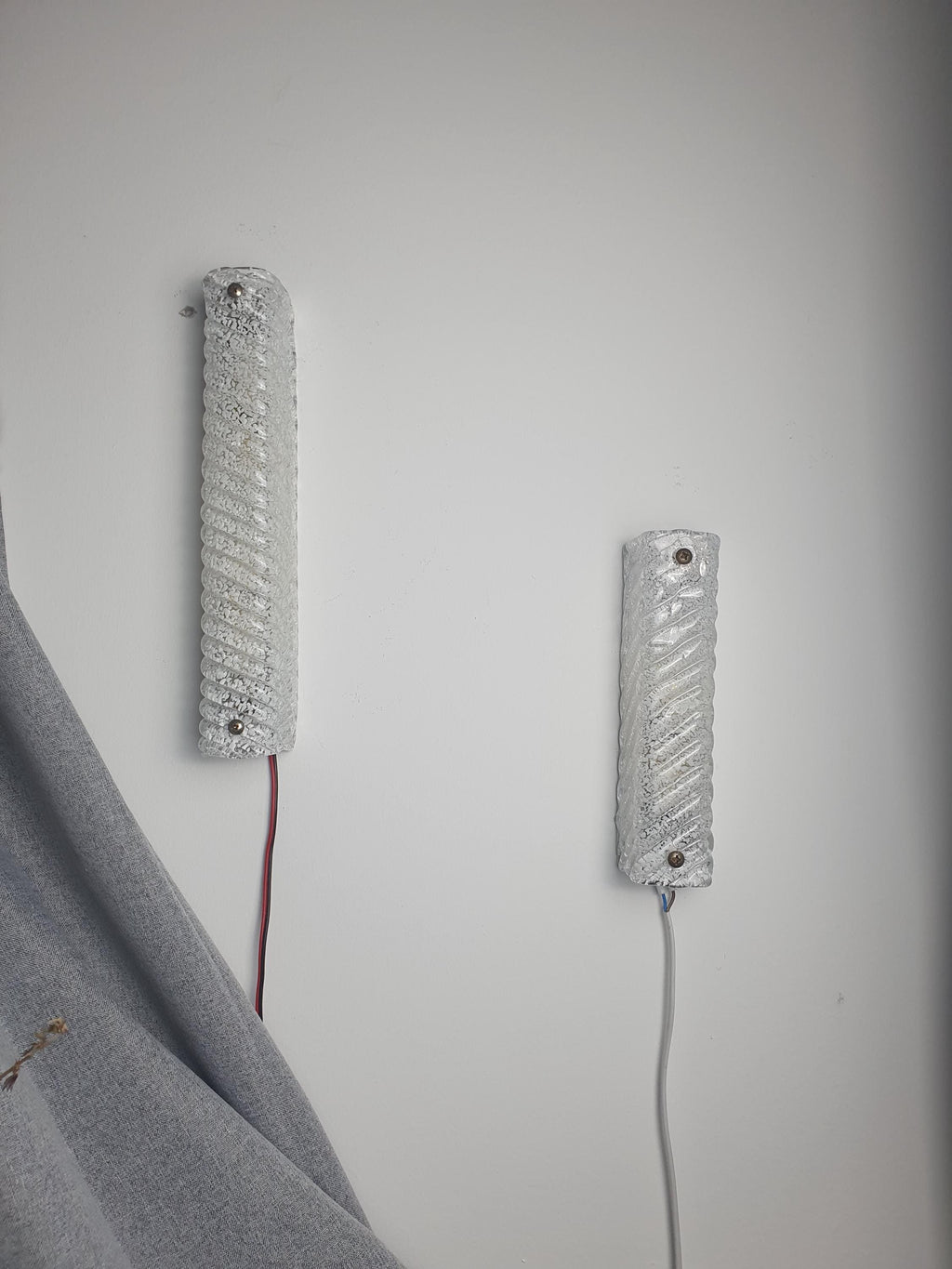 Two complementary sizes of vintage Murano glass ribbed rectangular sconces installed together, architectural composition