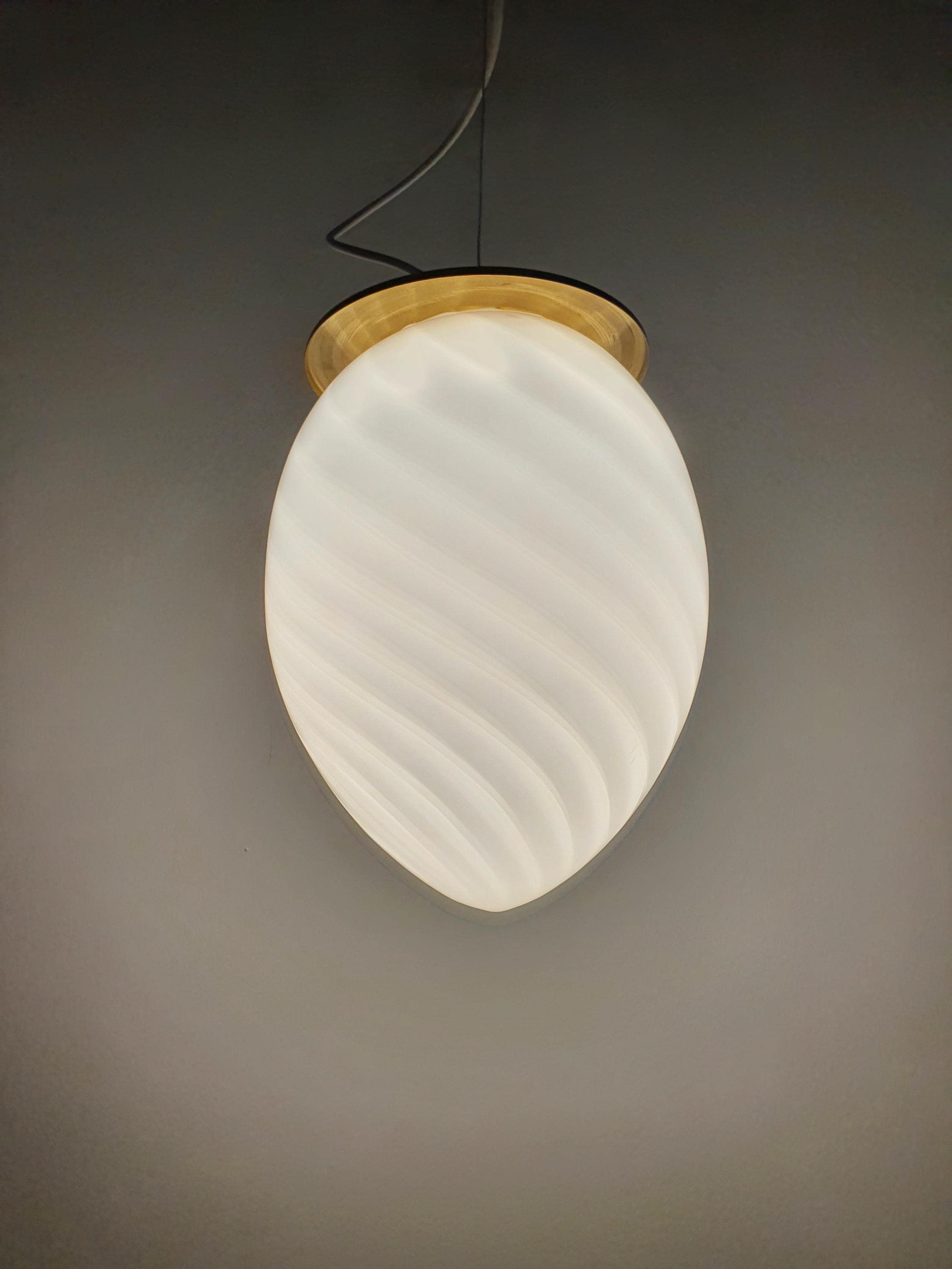 Vintage Murano white swirl egg pendant lit, warm transparent white swirl glow, brass fittings, Scandinavian MCM interior
