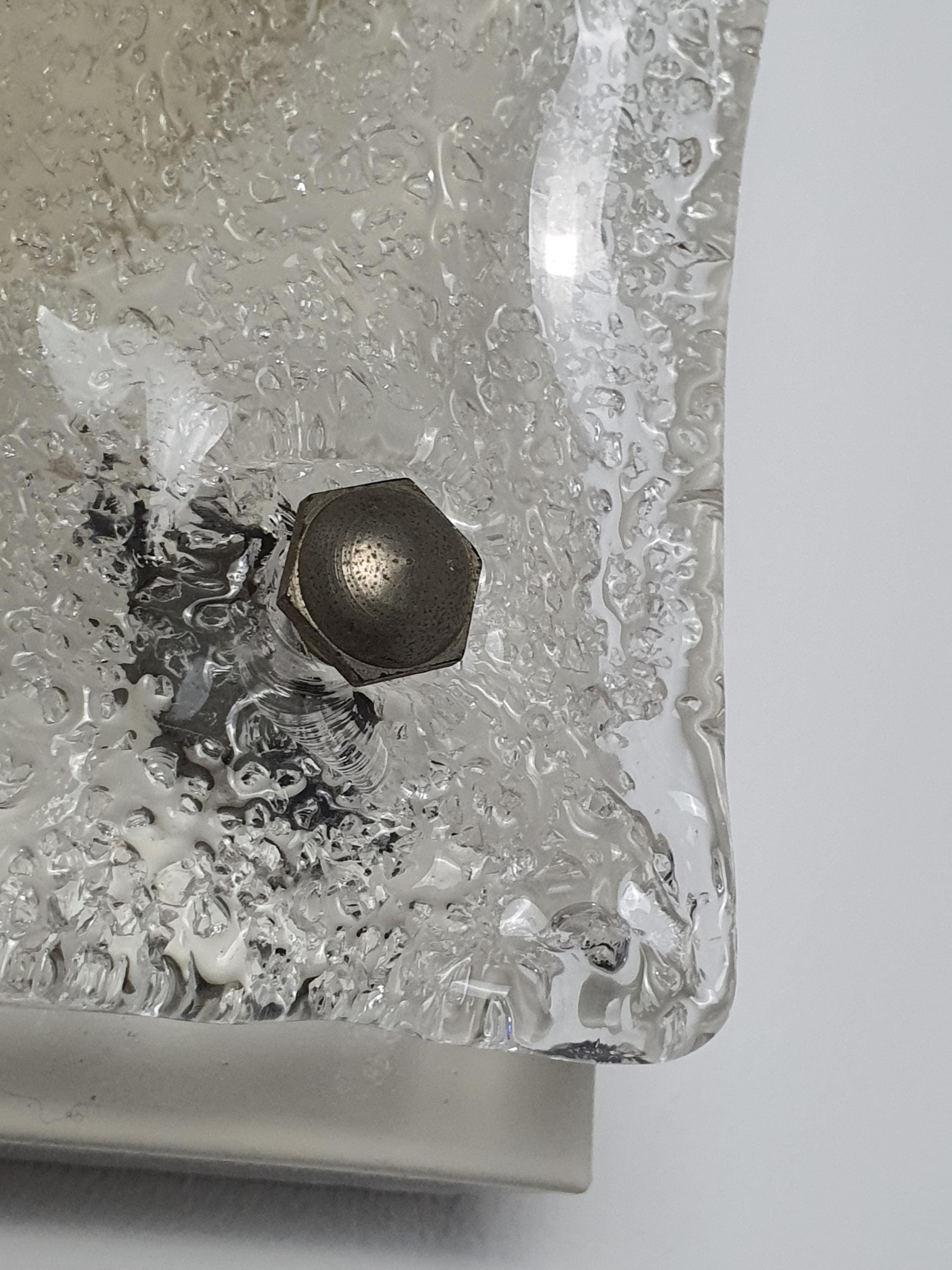 Close-up of ghiacciato iced glass texture with amber inclusions, vintage Mazzega Murano square light, geological uneven relief