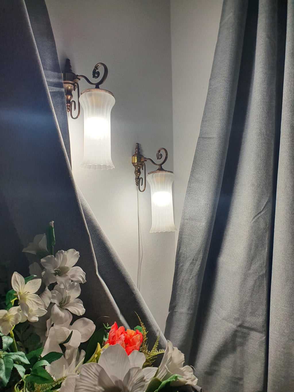 Pair of vintage Italian satin frosted flute wall sconces lit, warm soft ambient glow, brass bases, classical hallway setting