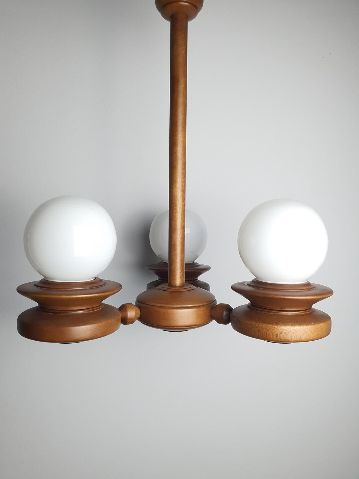 Close-up of solid handcrafted wood arm joint on vintage Space Age Sputnik chandelier, warm wood grain and vintage character