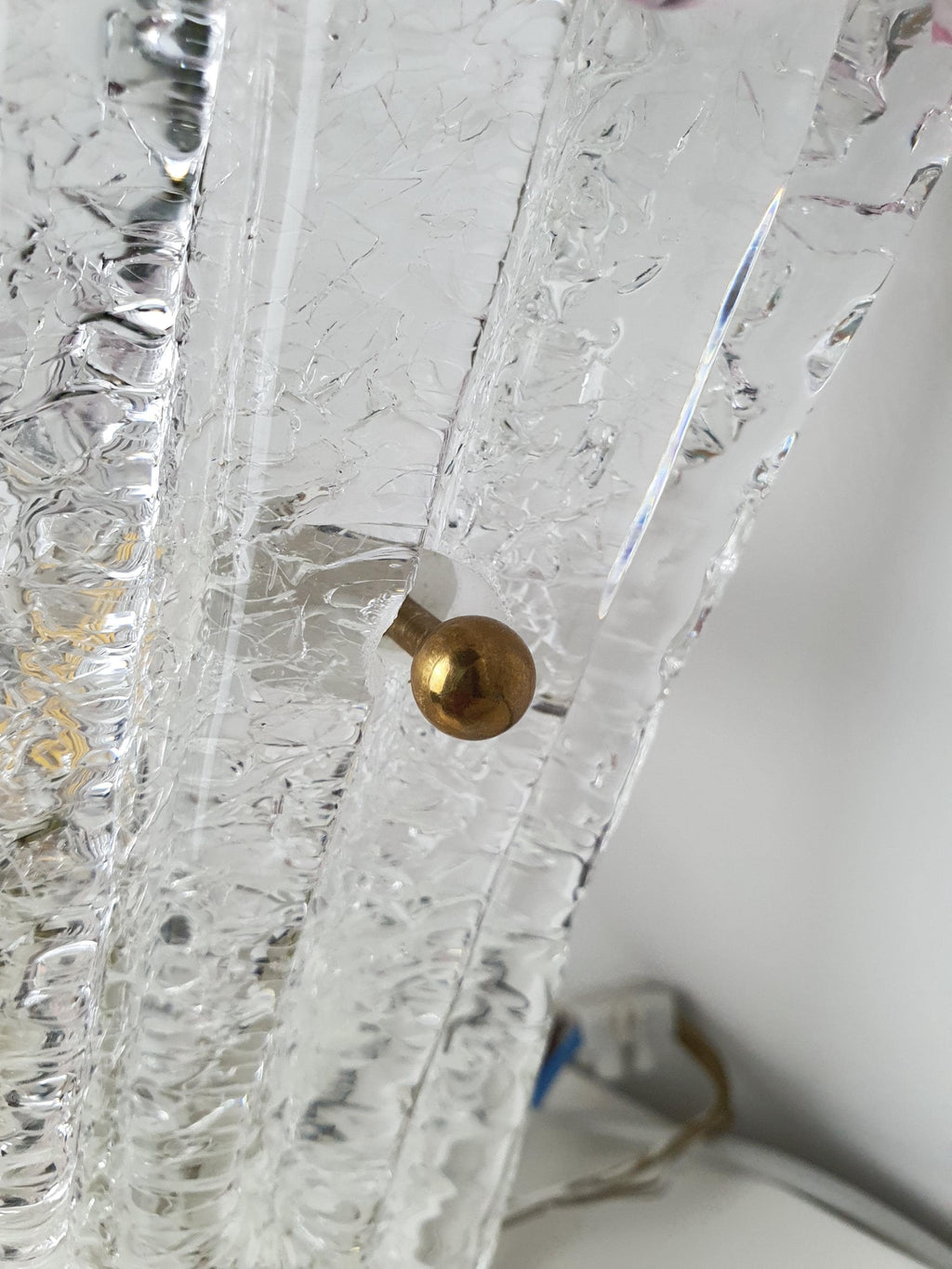 Transparent glass centre and pink textured edge of a Venetian wall sconce
