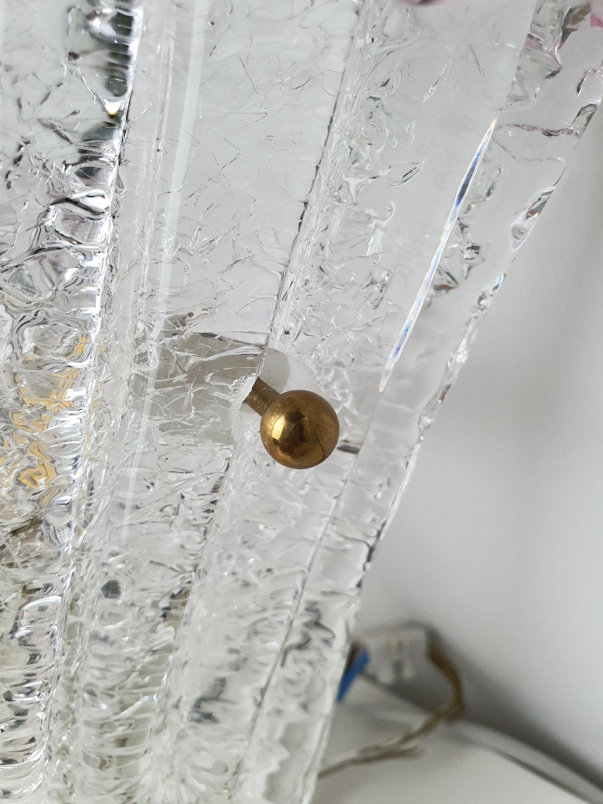 Transparent glass centre and pink textured edge of a Venetian wall sconce
