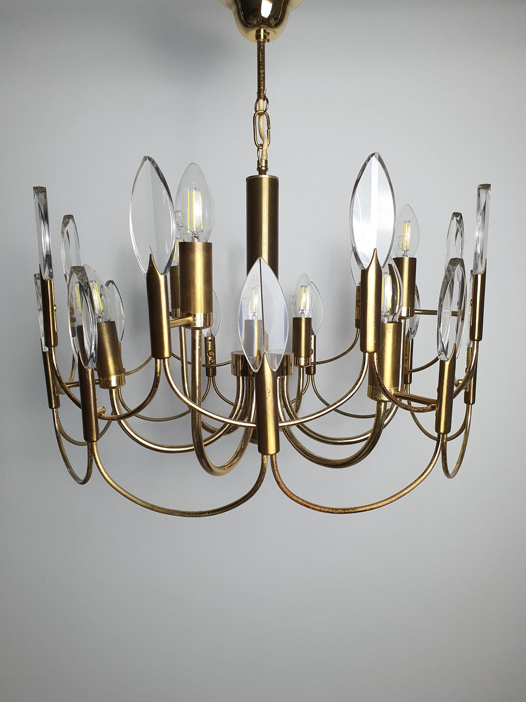 Sciolari-attributed chandelier front view, six brass arms with double-wave motif, faceted crystal drops, golden finish
