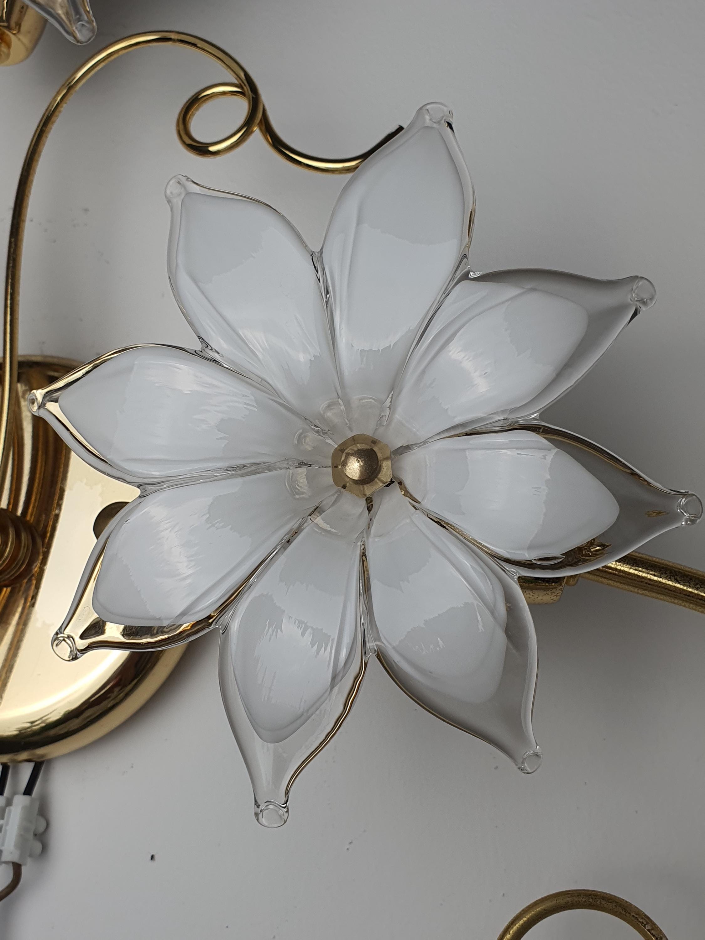 Vintage Italian Murano glass floral wall sconces unlit, showing asymmetrical white bloom silhouettes on gold-toned metal frames