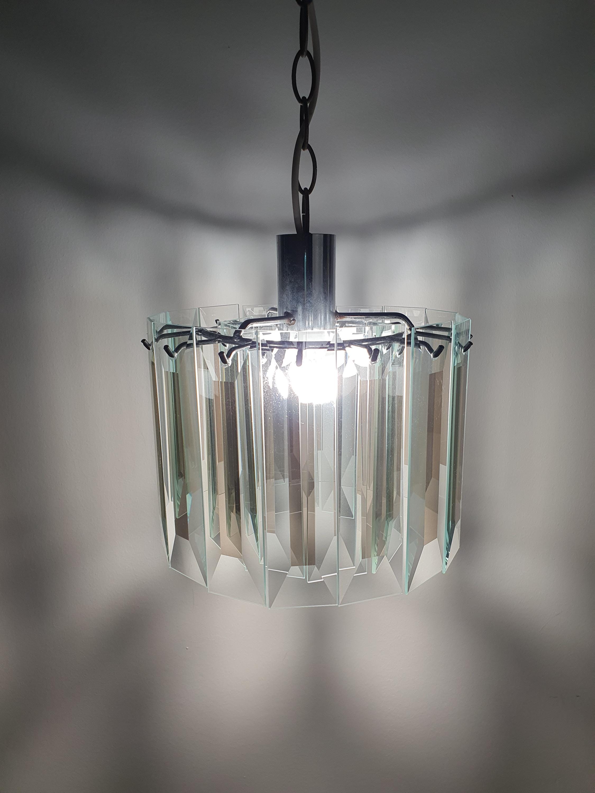 Vintage Art Deco chandelier in dressing room, crystal glass petal glow, aged chrome, compact MCM geometric statement