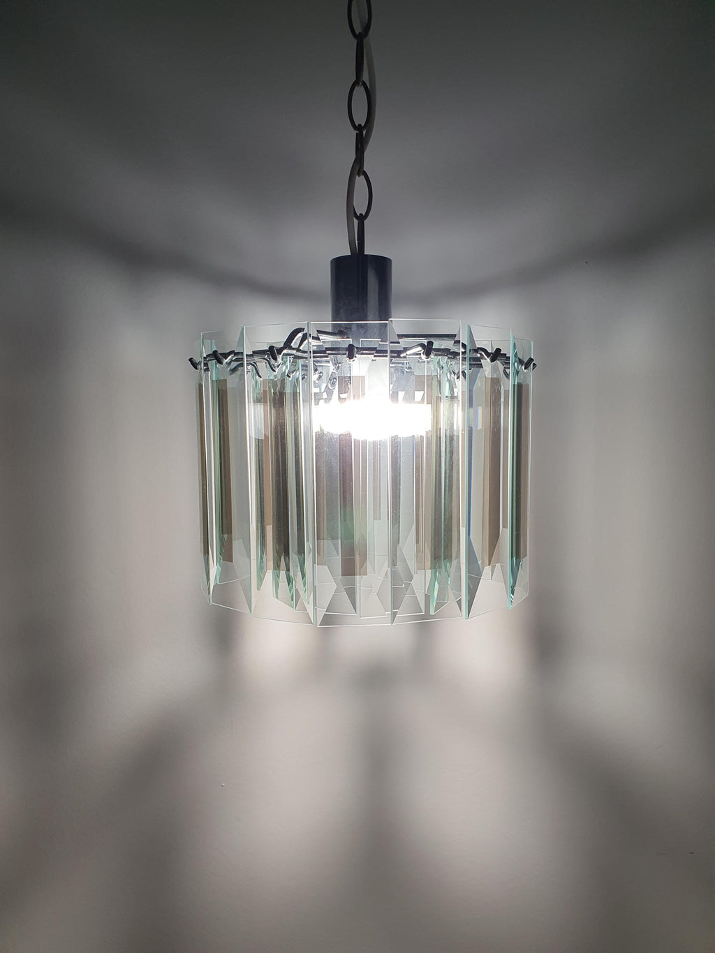 Vintage Art Deco chandelier lit, clear crystal glass petal sparkle and refraction, aged chrome frame, intimate warm glow