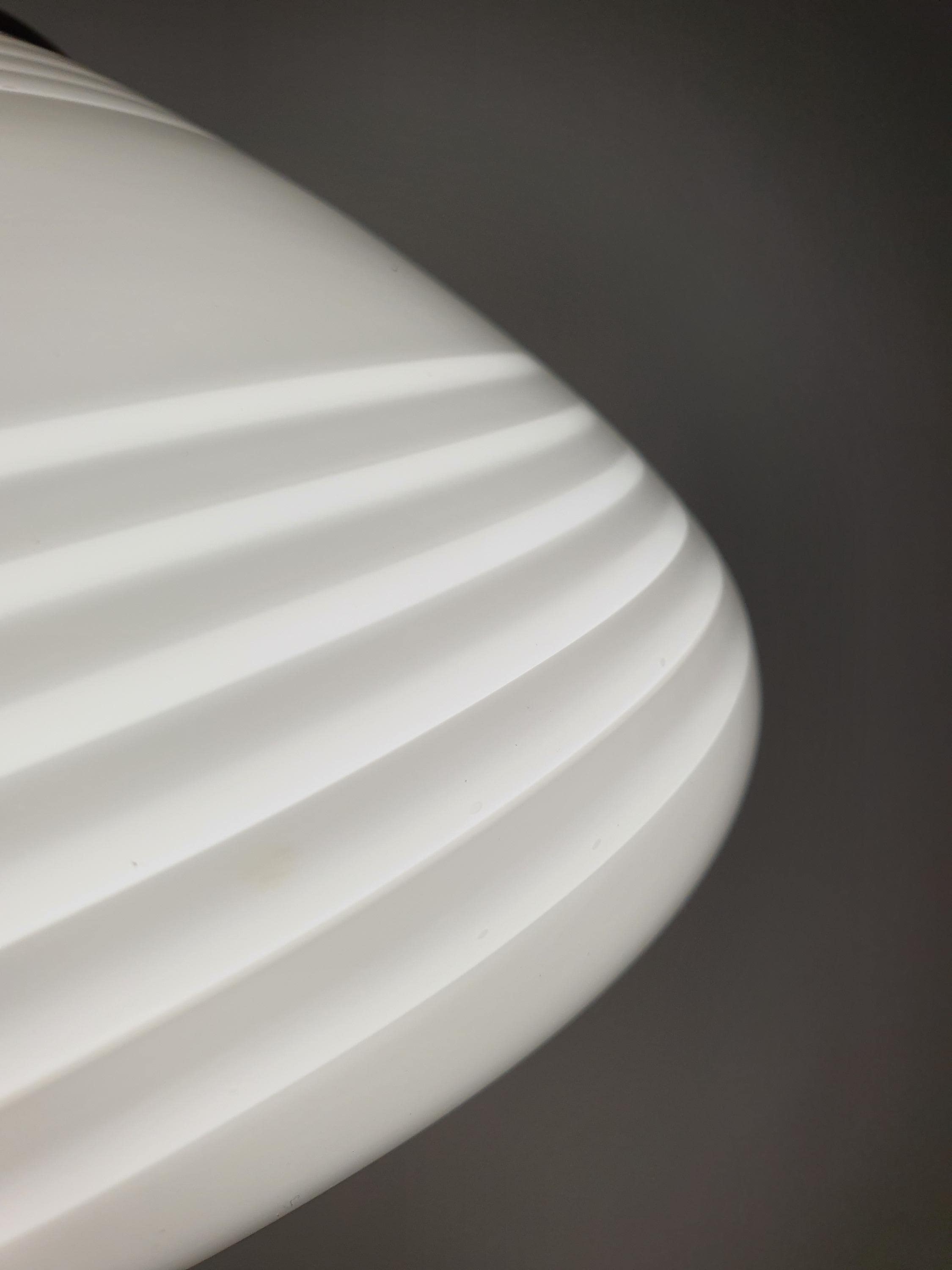 Close-up of white swirl decoration on vintage Murano large oblate globe pendant, smooth hand-blown glass surface