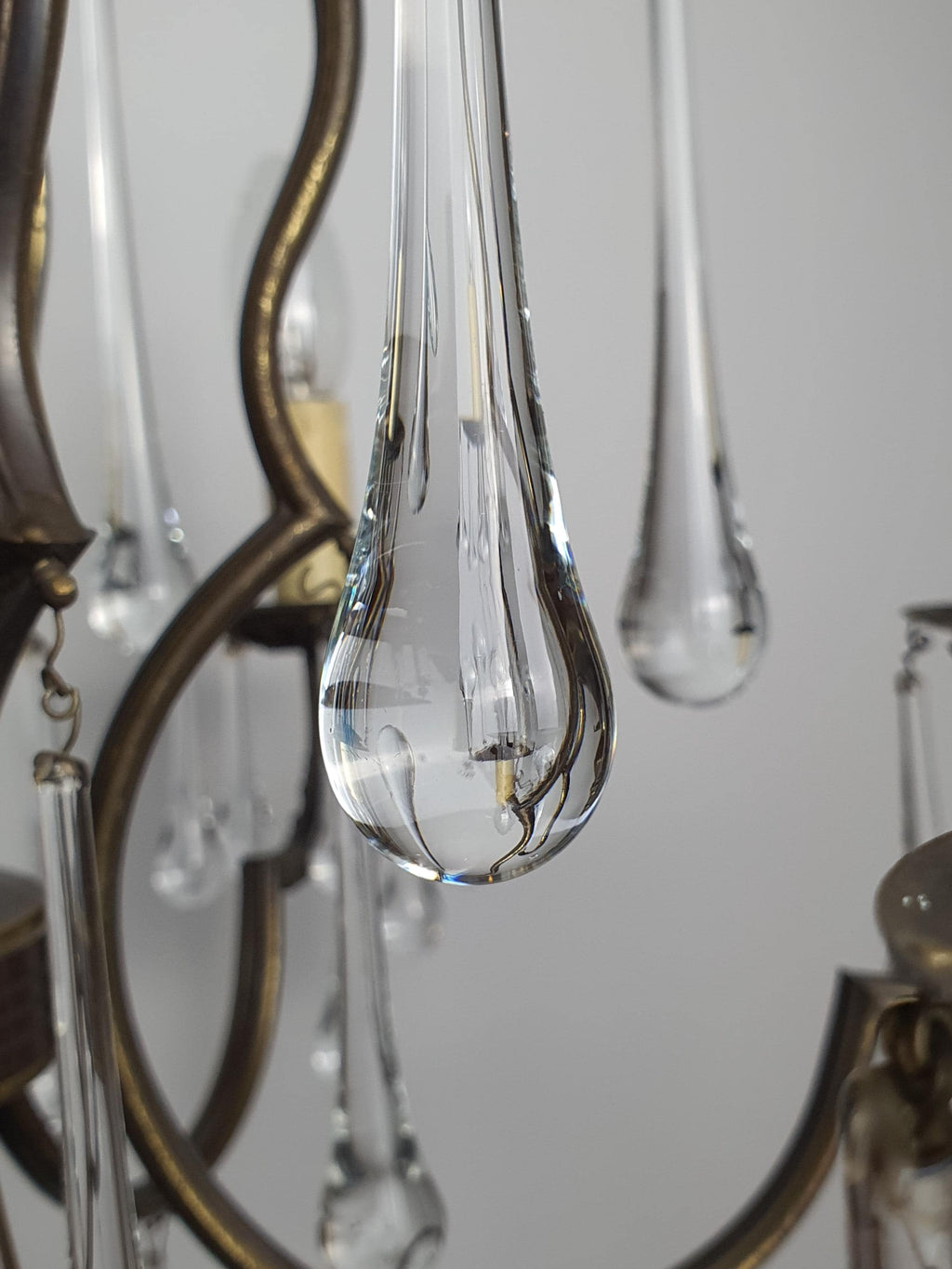 Vintage Italian brass chandelier front view, 6 scrolling arms, cascading clear Murano glass teardrops, multiple drop sizes