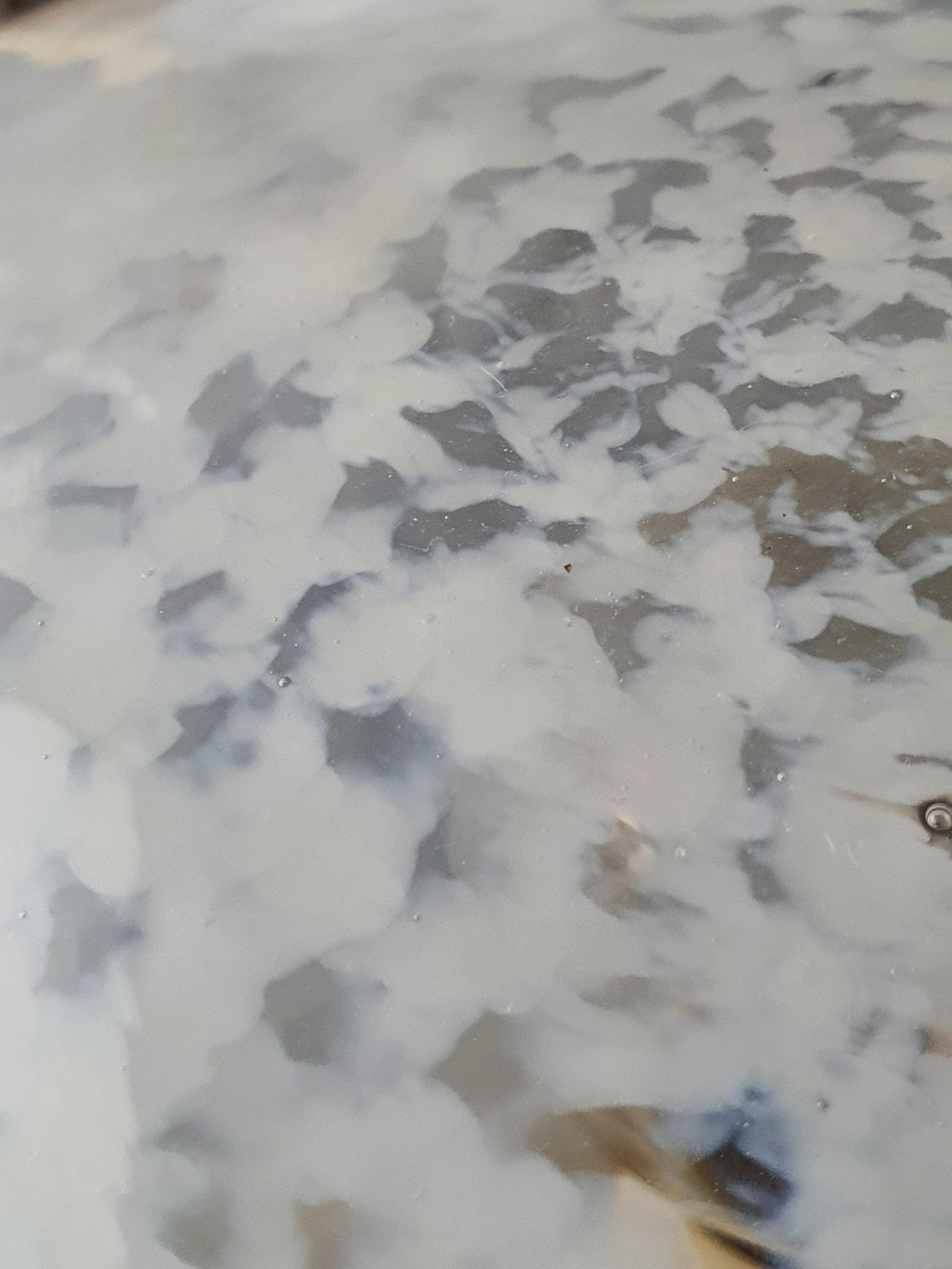 Close-up of white spotted moonstone effect in clear Murano glass globe table lamp shade, Vetri di Murano