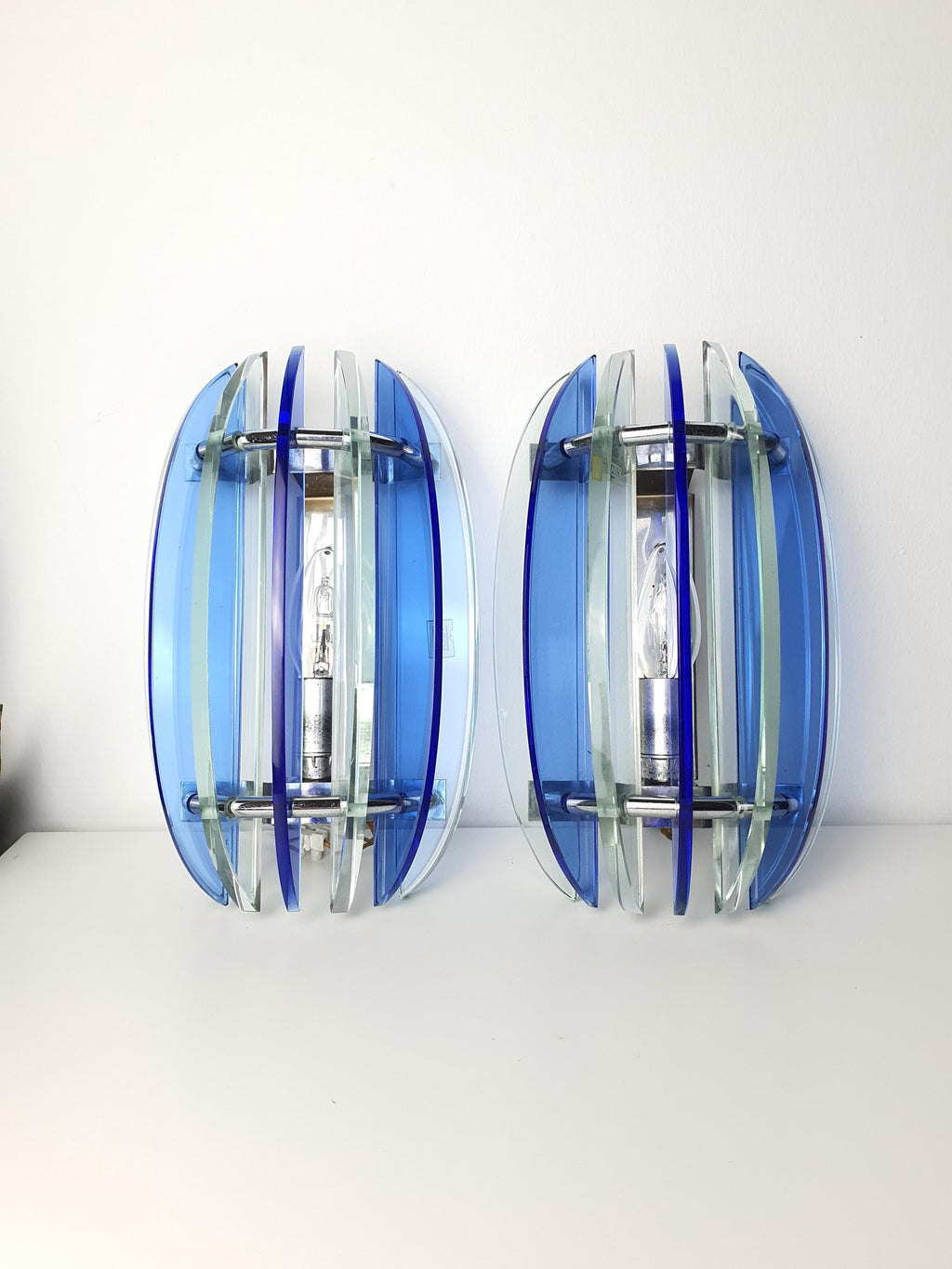 Vintage Veca blue sconce — illuminated, rich cobalt glow through pressed glass