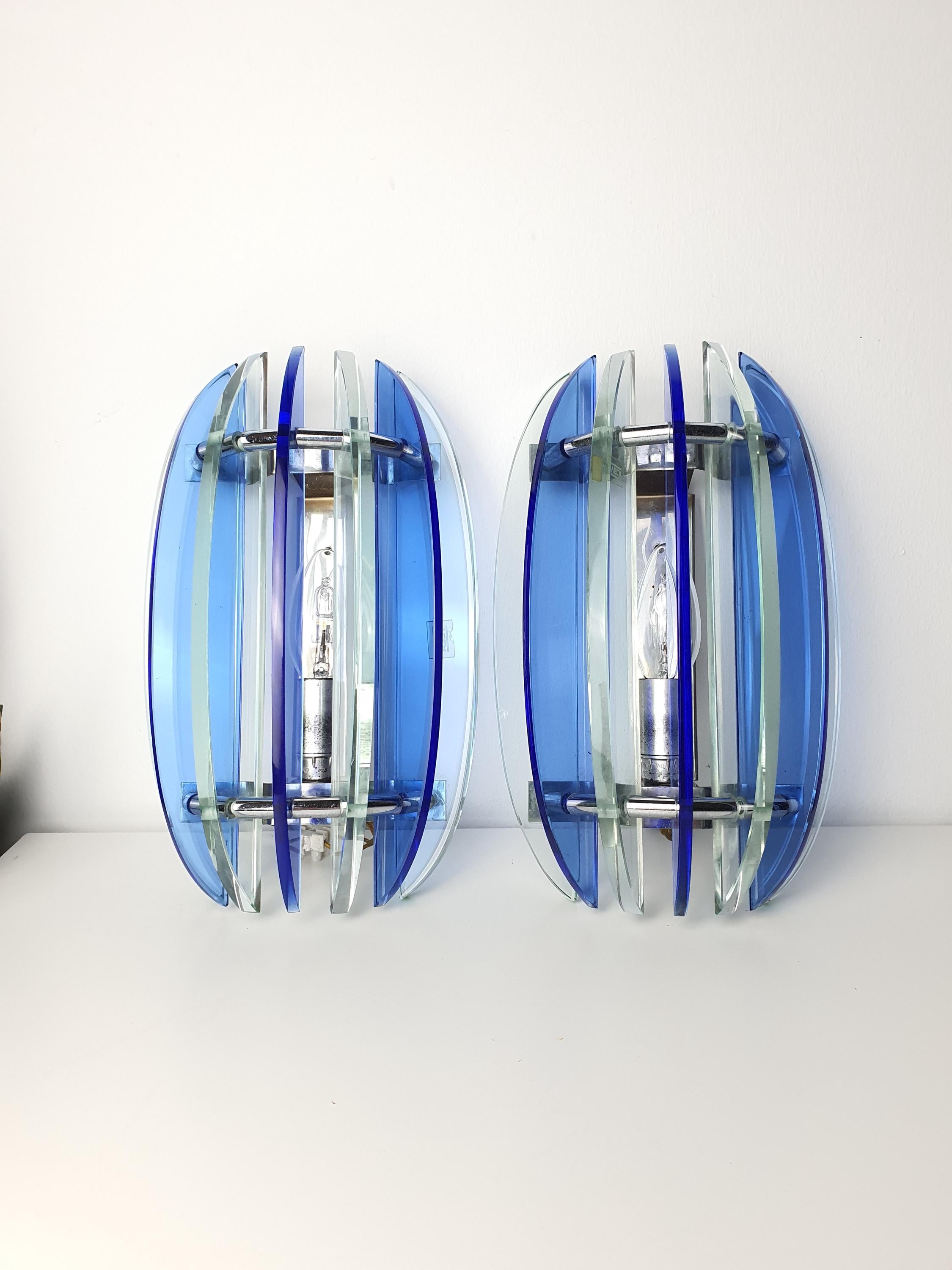 Vintage Veca blue sconce — illuminated, rich cobalt glow through pressed glass