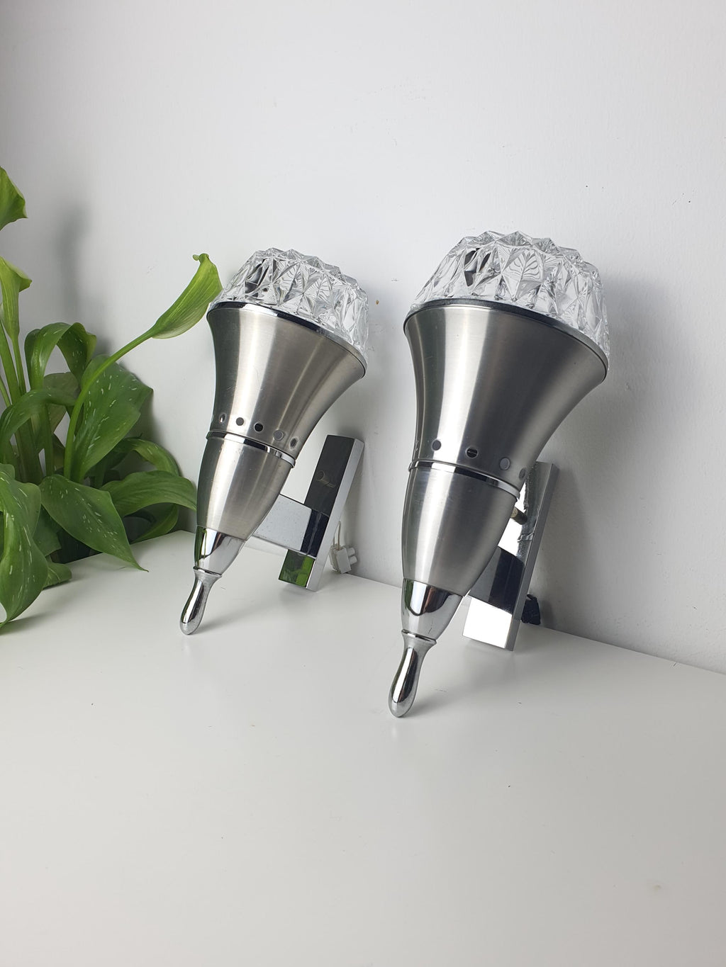 Set of 2 vintage Brutalist Space Age wall sconces — silver chrome metal and clear stamped glass, front view