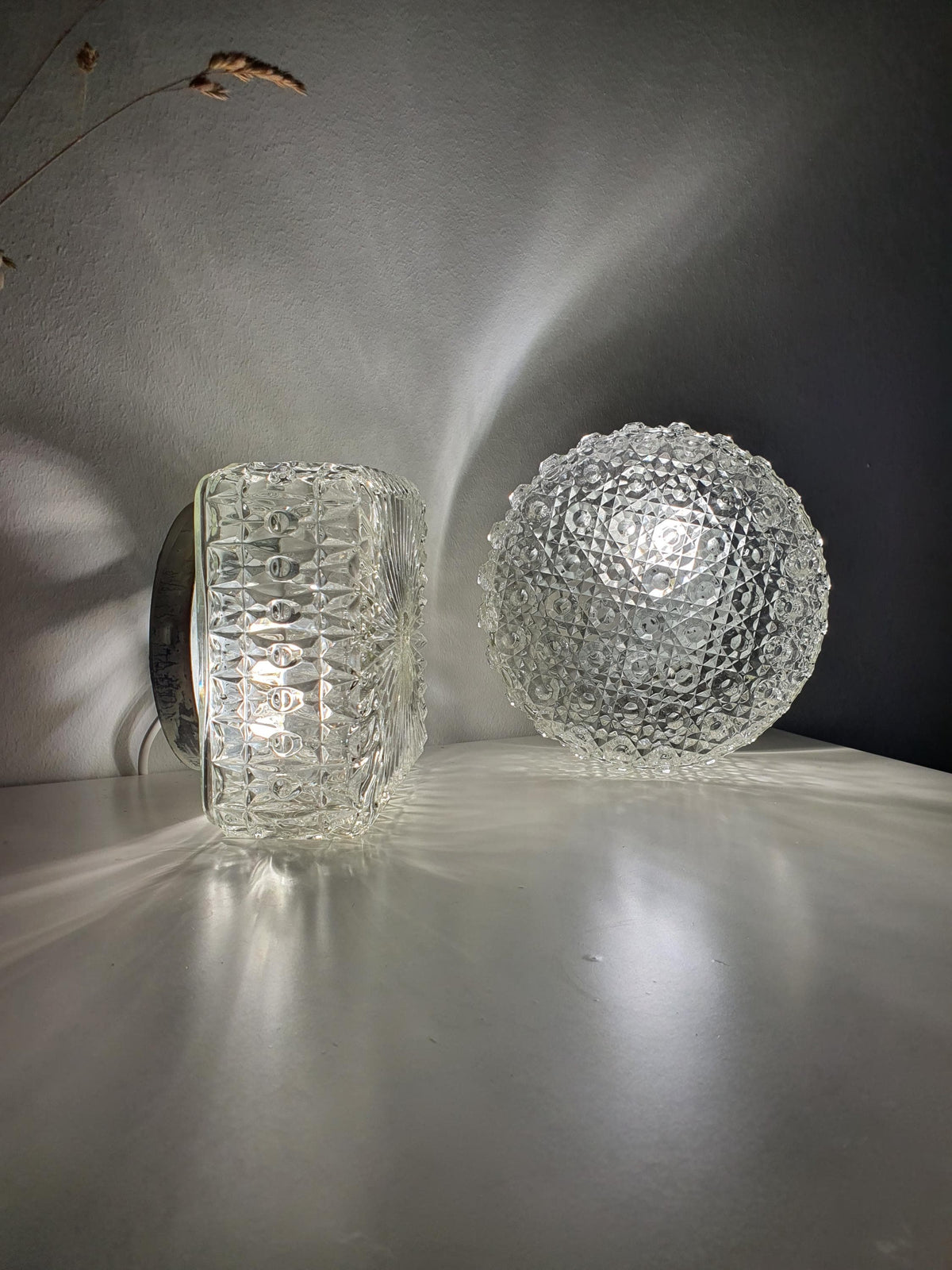 Complementary round and square glass shades with matching relief texture
